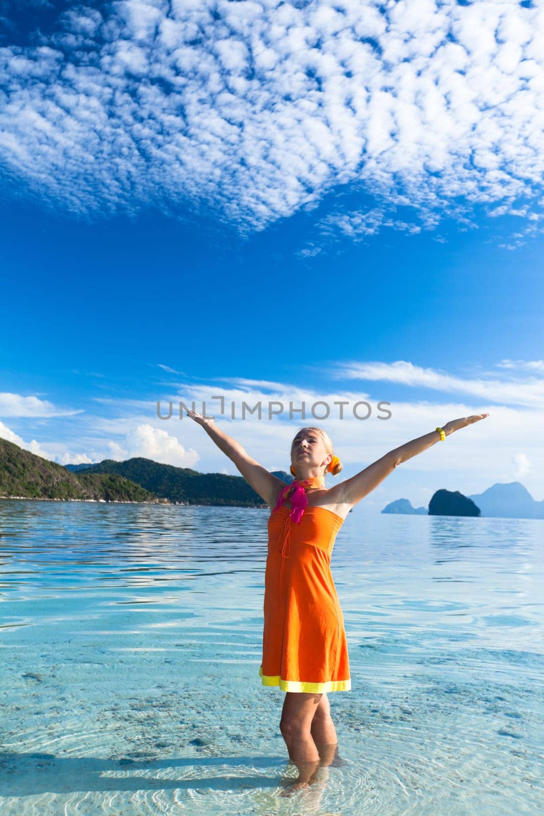 Woman in orange dress on the tropical beach