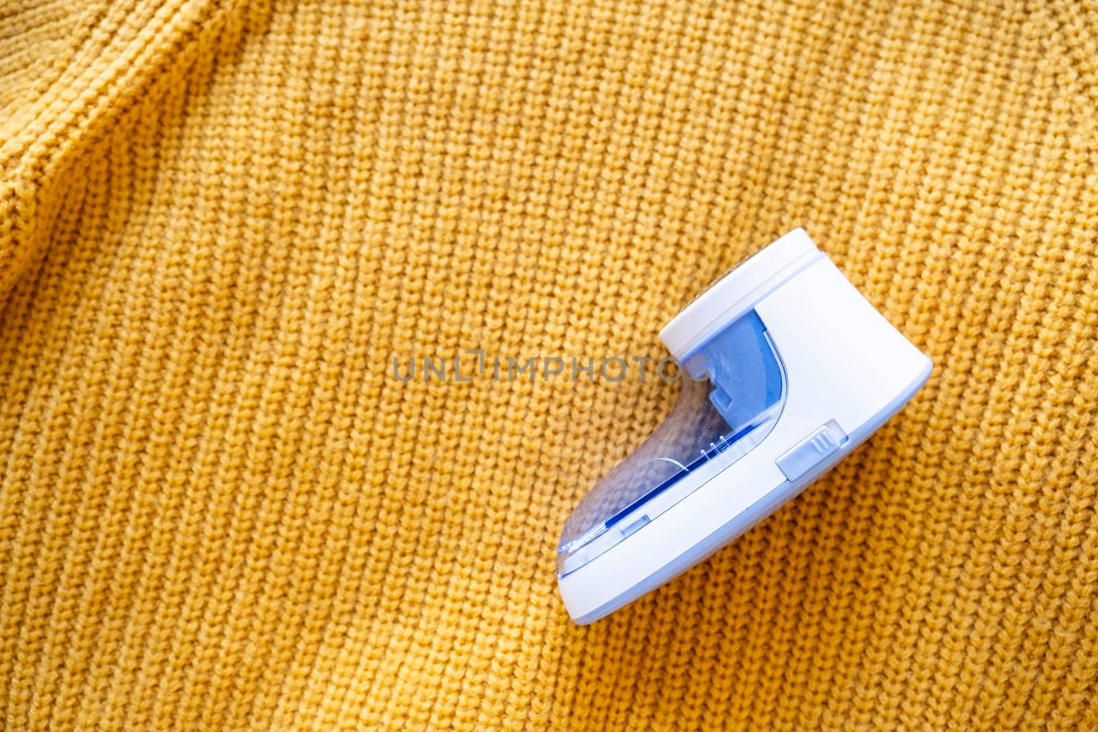 anti-pilling razor machine on yellow sweater by Desperada