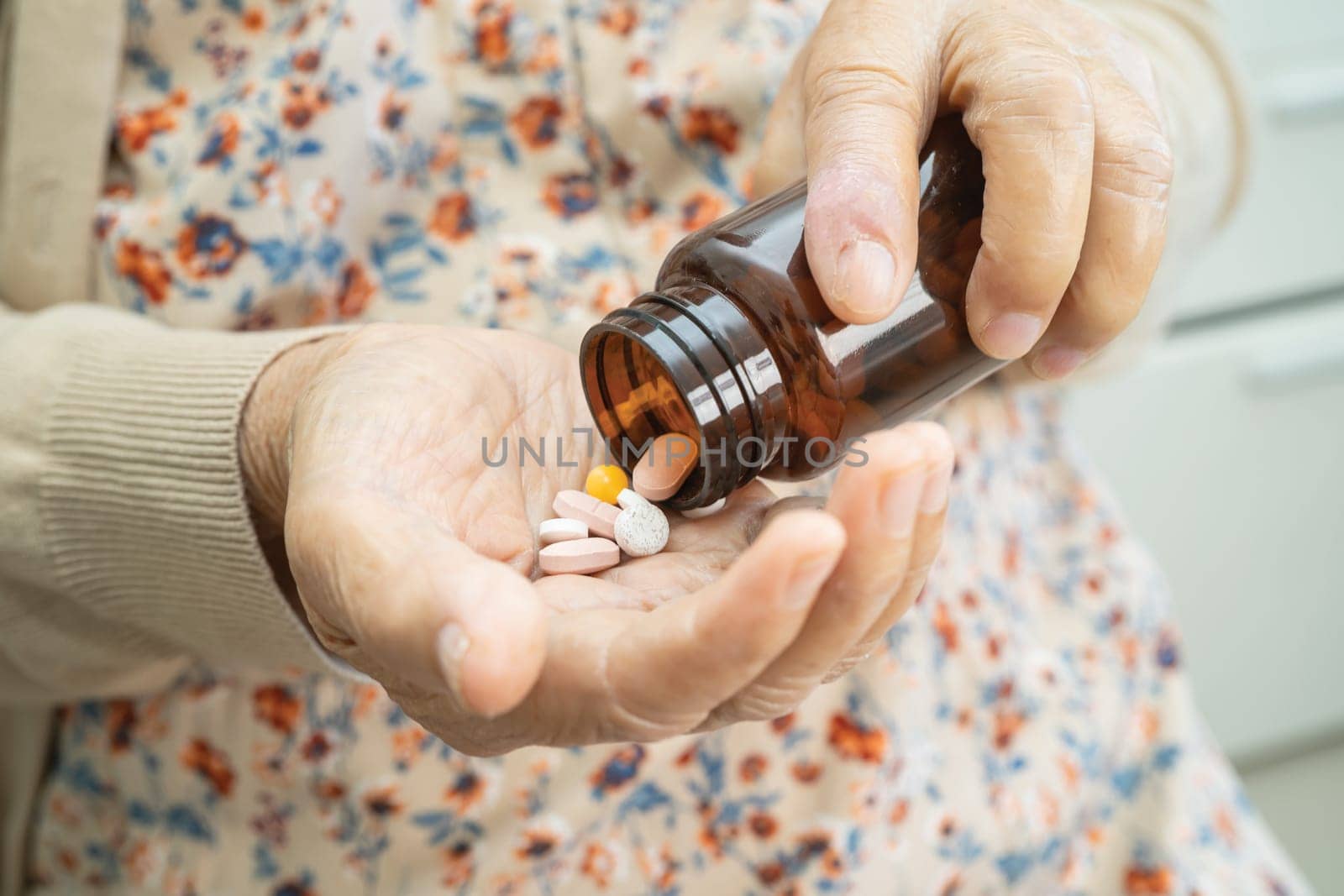 Asian senior woman patient holding antibiotics capsule pills  for treatment infection patient in hospital, Pharmacy drugstore concept.