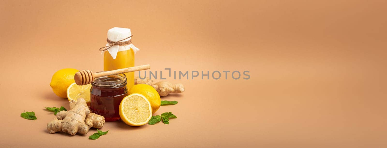 Composition with detox drink, sea buckthorn berries, lemons, mint, ginger, honey in glass jar. Food for immunity stimulation and against flu. Healthy natural remedies to boost immune system.