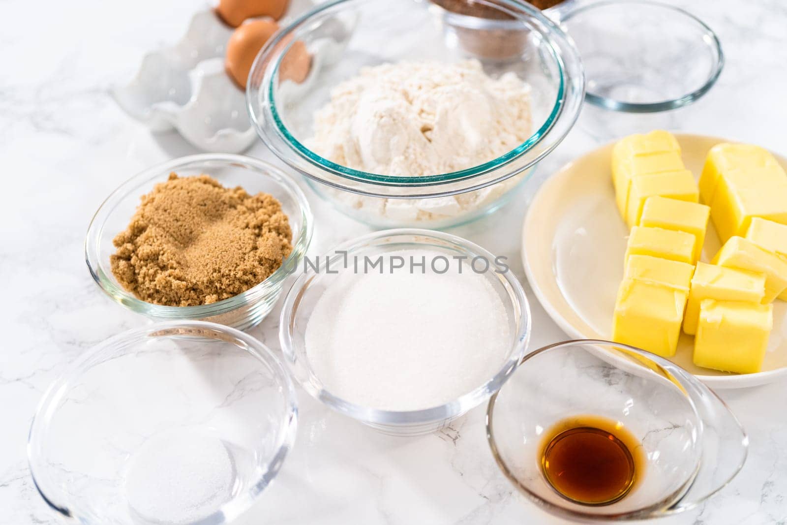 Measured ingredients in glass mixing bowls to bake chocolate cookies with chocolate hearts for Valentine's Day.