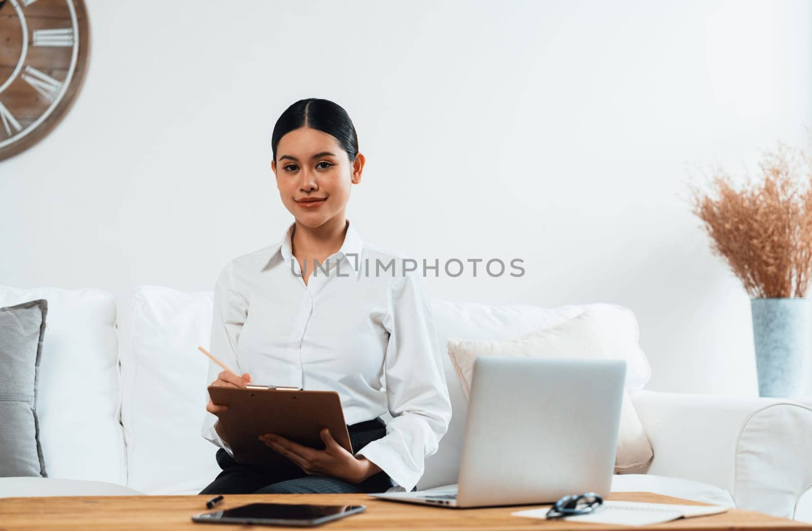 Psychologist woman in clinic office professional portrait with friendly smile feeling inviting for patient to visit the psychologist. The experienced and confident psychologist is uttermost specialist