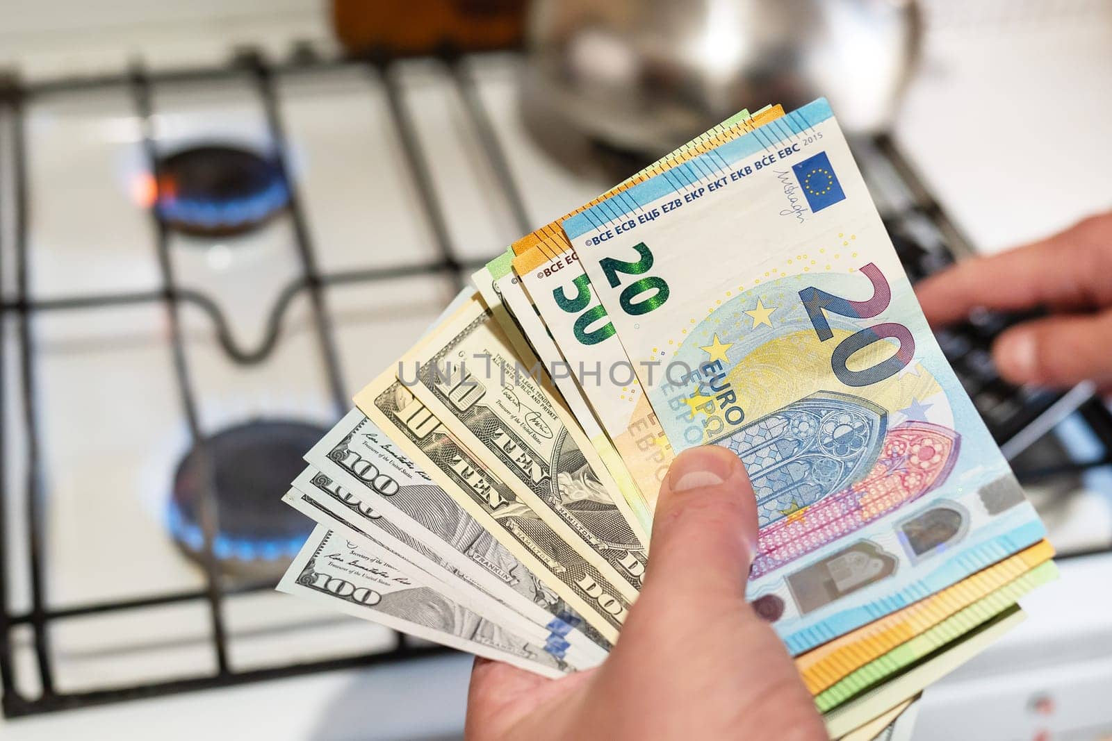 Payment of utilities. Euro and dollar bills lie near a burning gas burner. The concept of increasing the cost of natural gas supply and payment. Energy crisis. High cost, the price of gas