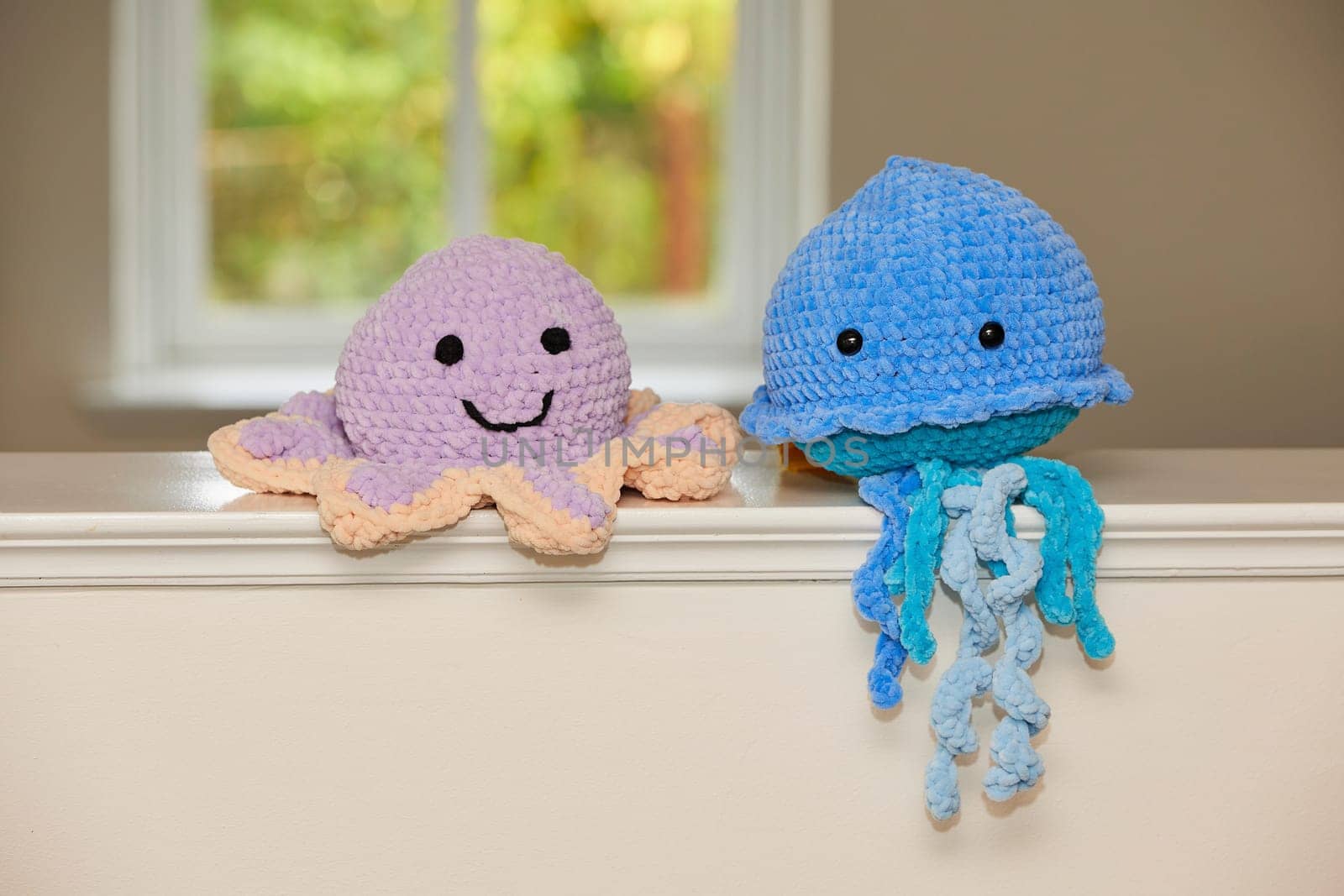 Cute knitted toy octopus and jellyfish at home.