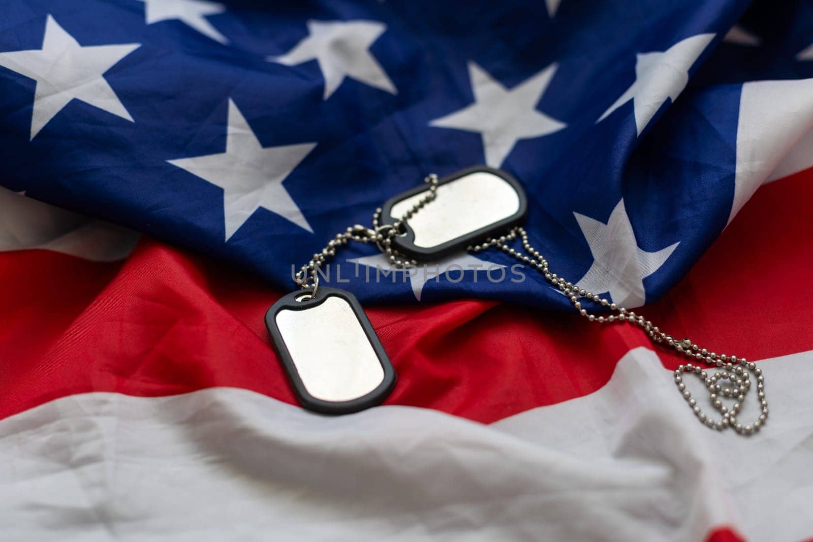 Veterans Day USA flag with dog tags on rustic red wood background, closeup. by Andelov13