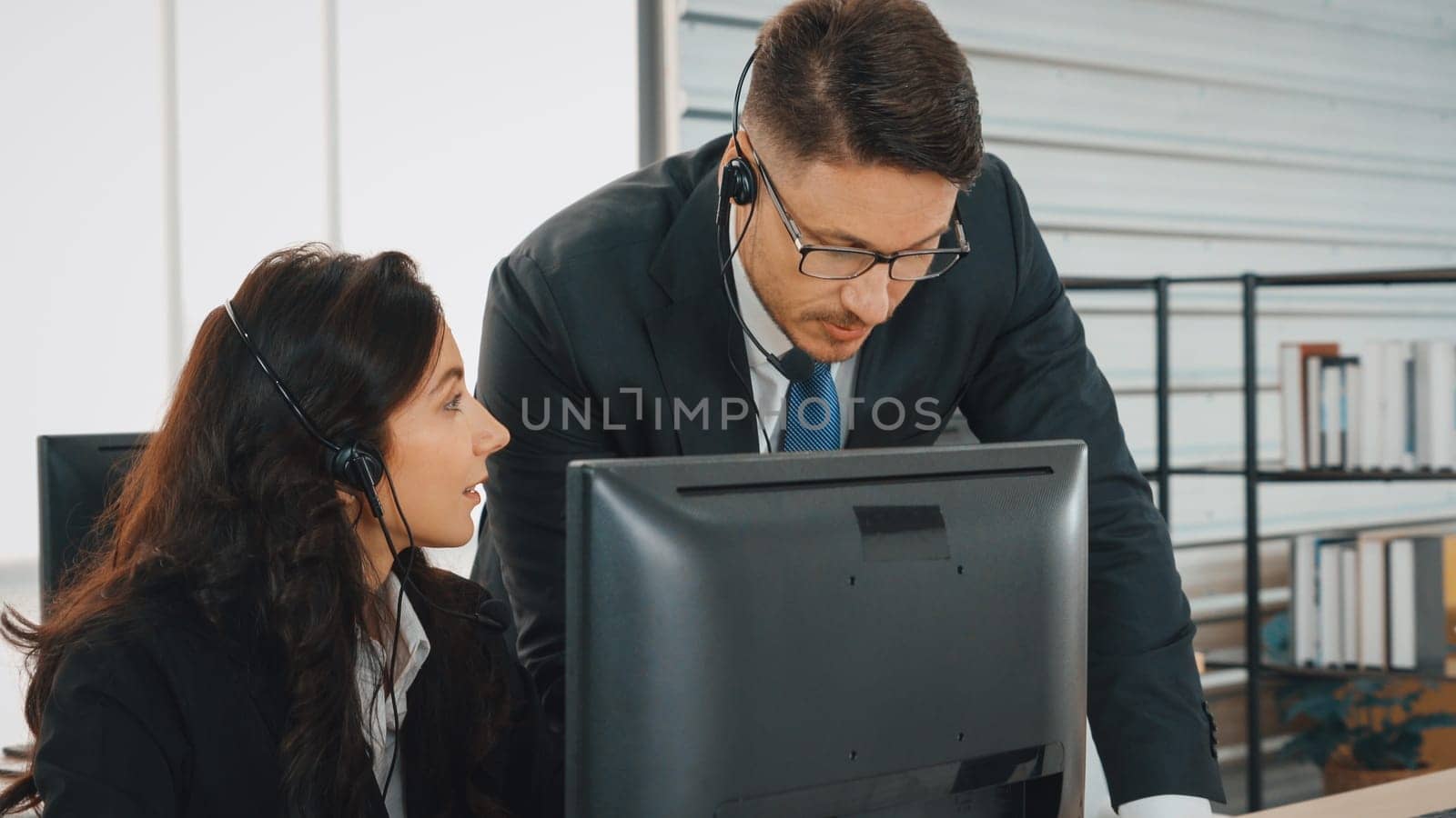 Business people wearing headset working in office to support remote customer or colleague. Call center, telemarketing, customer support agent provide service on telephone video conference call. Jivy