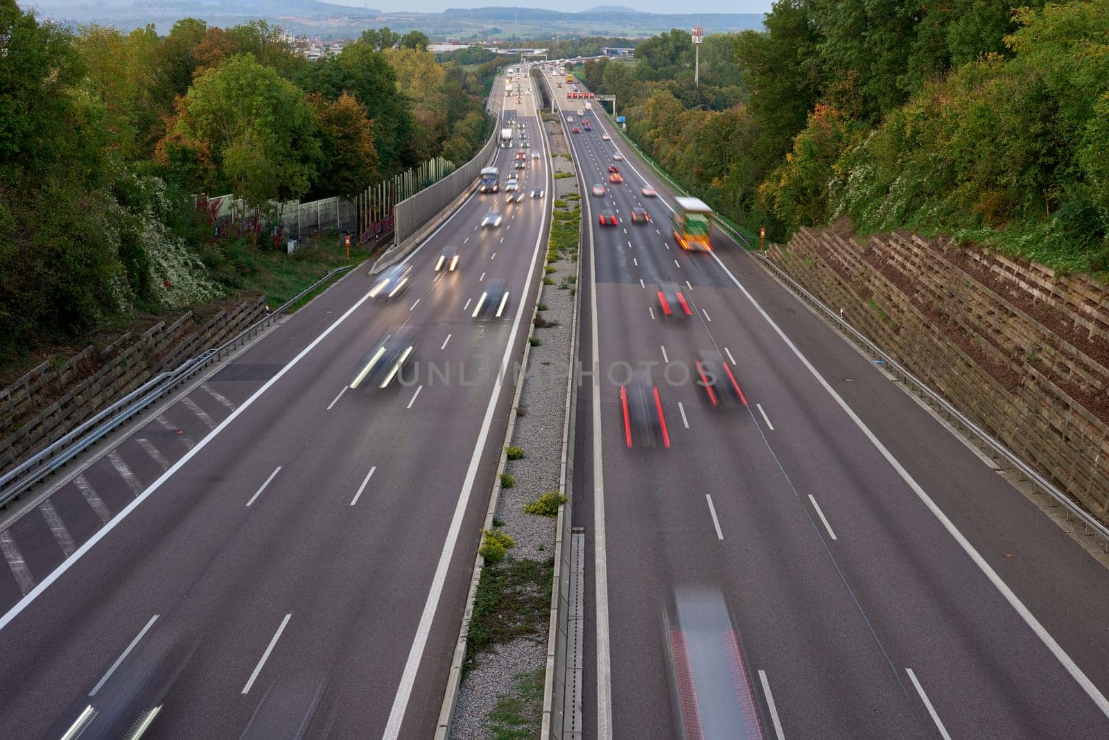 Long exposure photo of traffic with blurred traces from cars, top view. road, cars, blurred traffic, evening, top view. Highway at evening, blue hour illuminated by the traffic of cars by Andrii_Ko