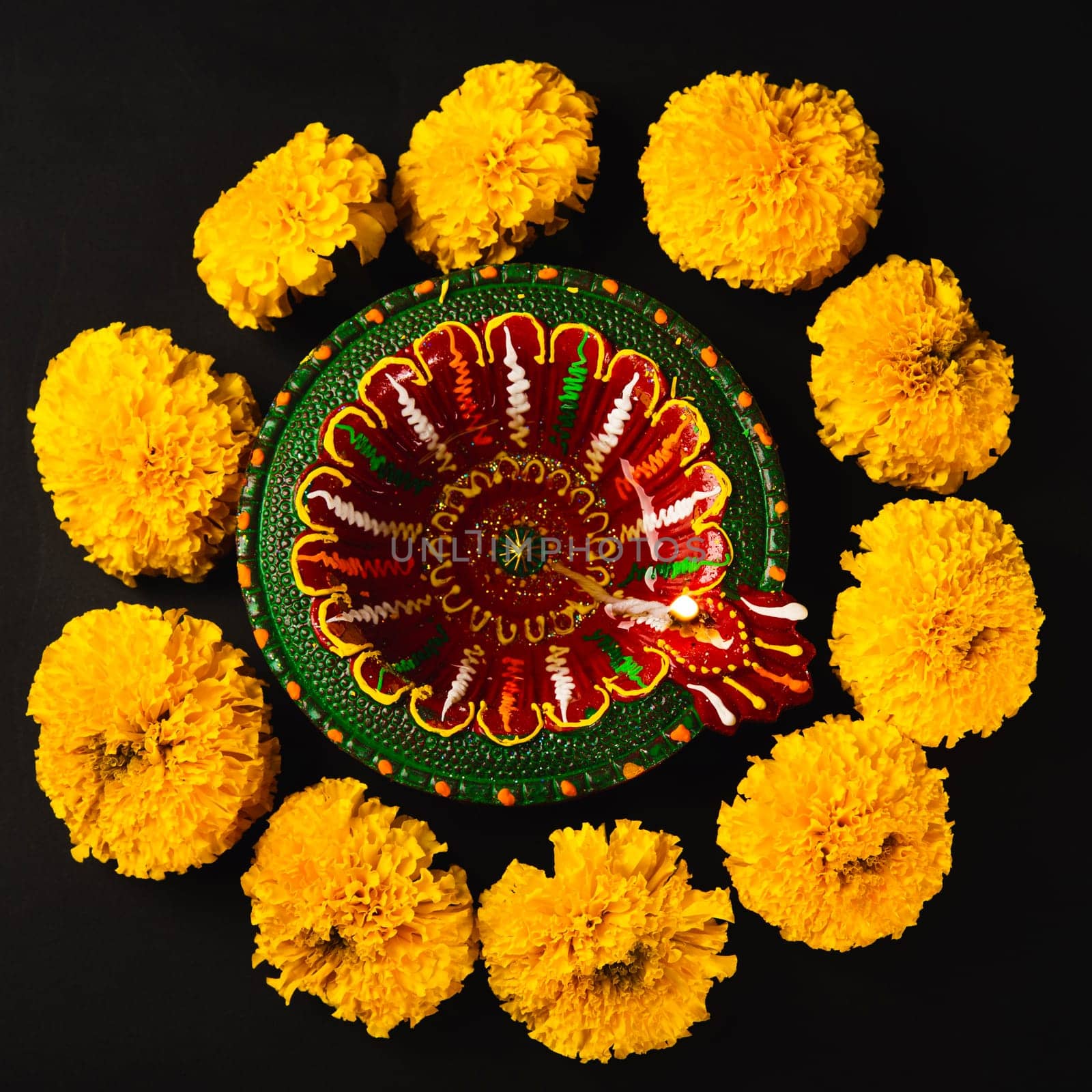 Diwali's splendor revealed, A Diwali lamp and exquisite flower rangoli on a dramatic black backdrop. Perfect for festive invitations, religious ceremonies, and celebrations.