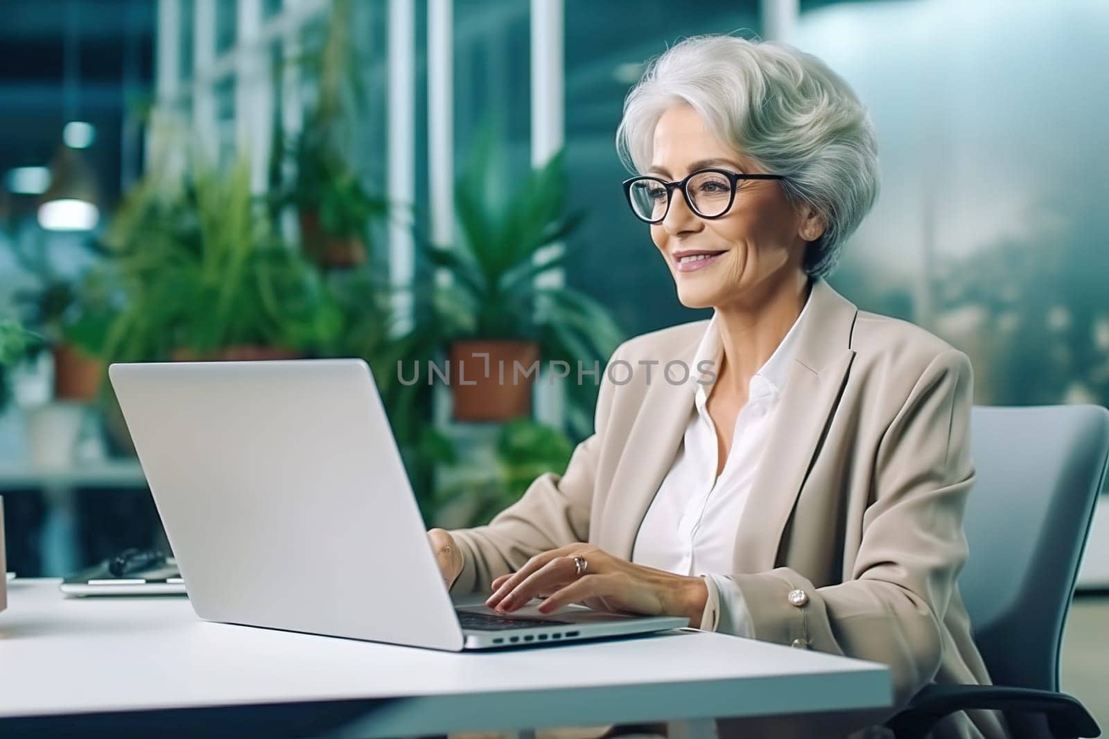 An old, successful woman works on a computer. High quality photo