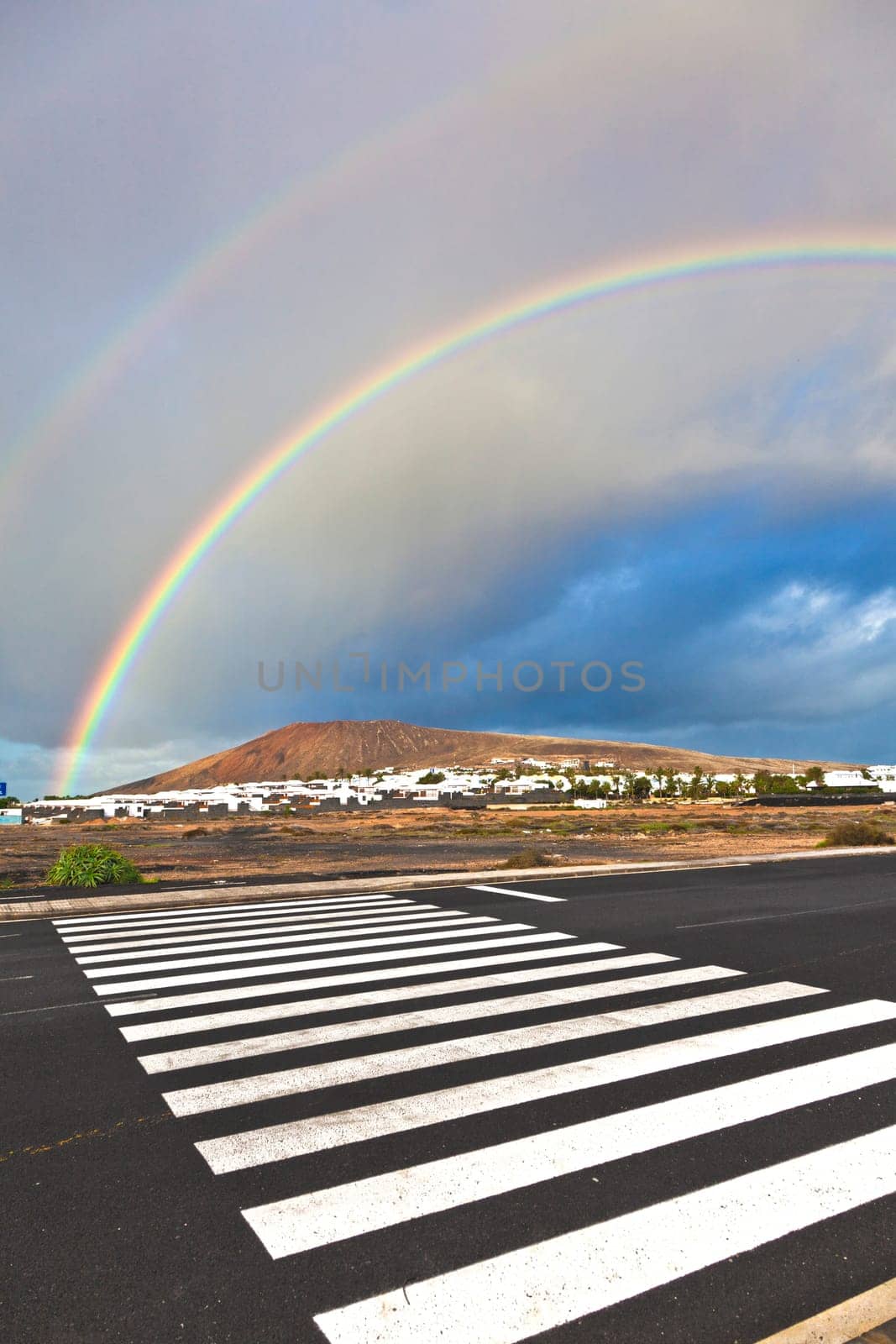 beautiful rainbow over the mountain with dark clouds