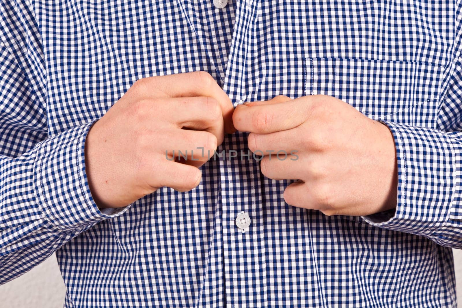 man closing his shirt