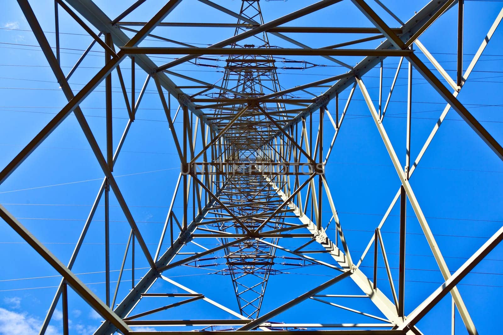 Steel electricity pylon on bright blue sky
