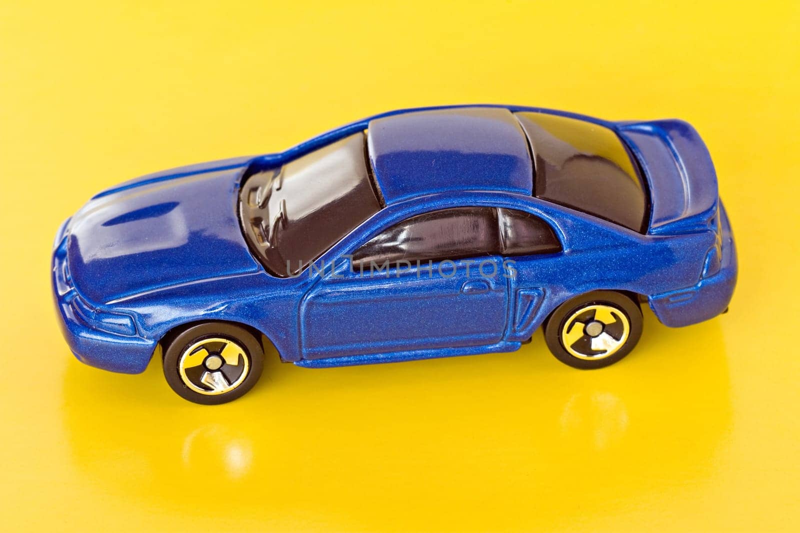 blue mini car isolated on yellow background