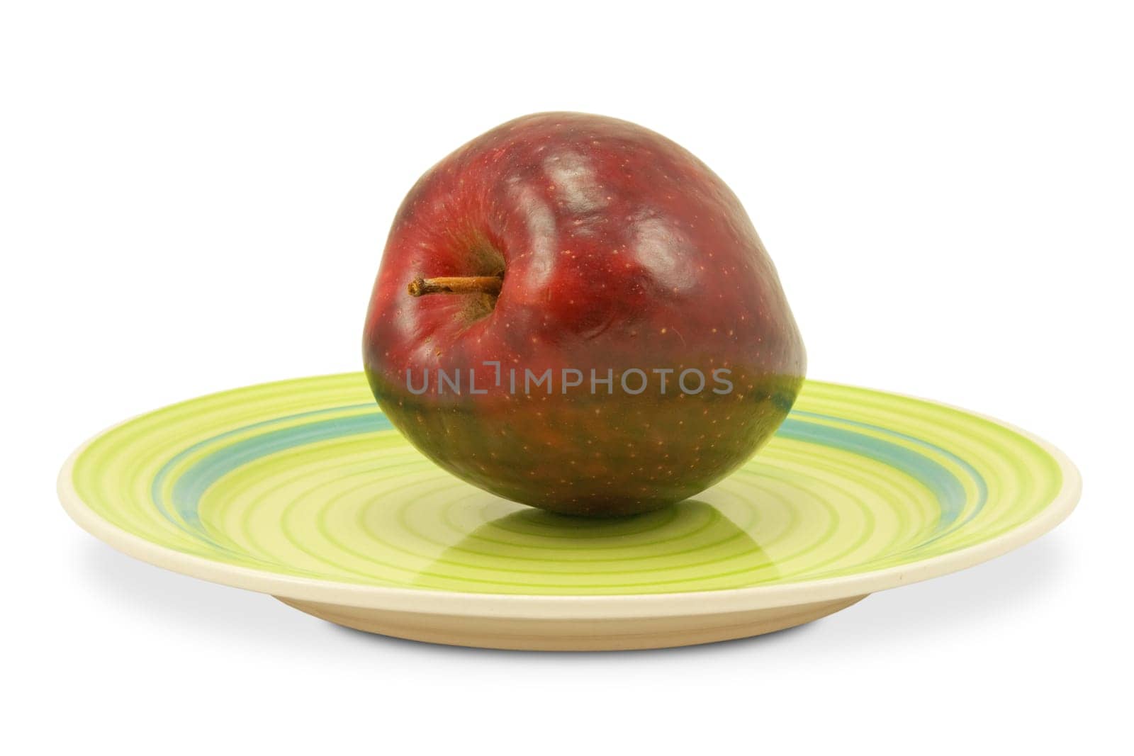 green plate with red apple on white background