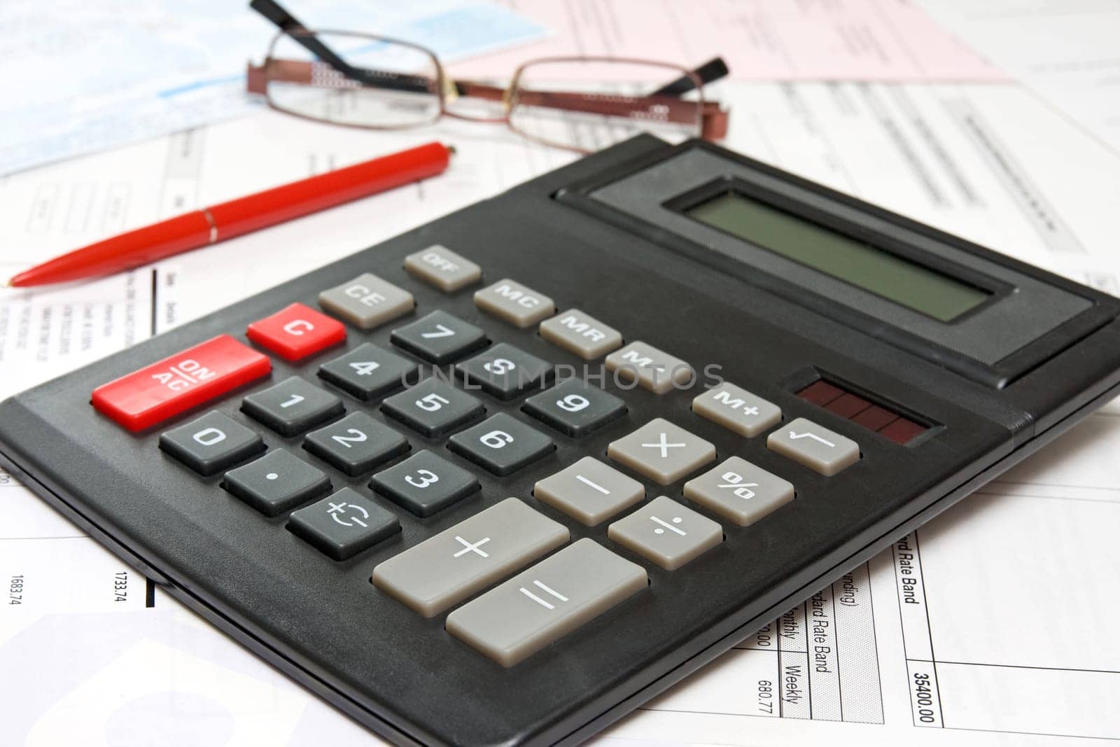 financial analysis concept with calculator,pen and glasses