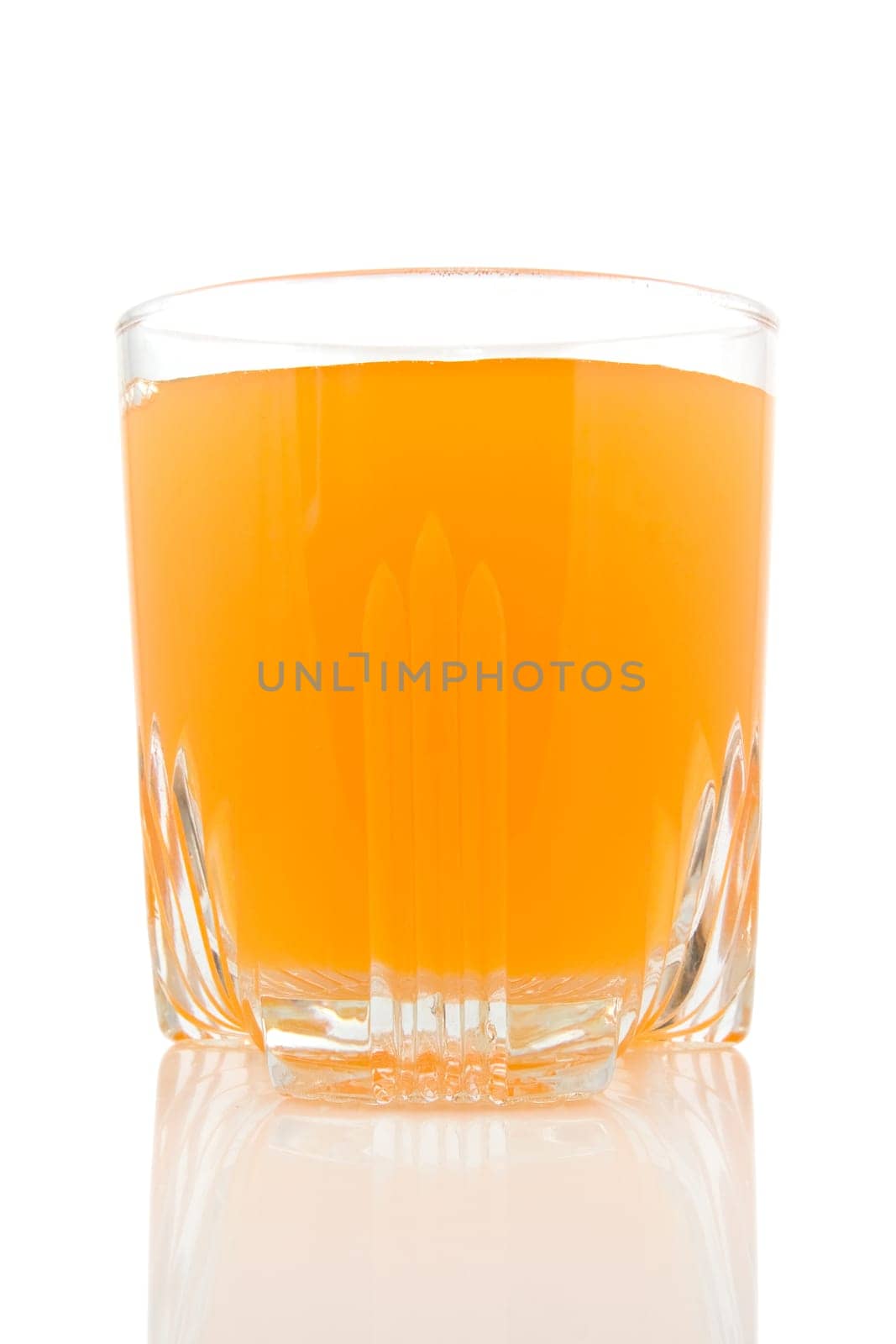 glass of juice on white background with reflection