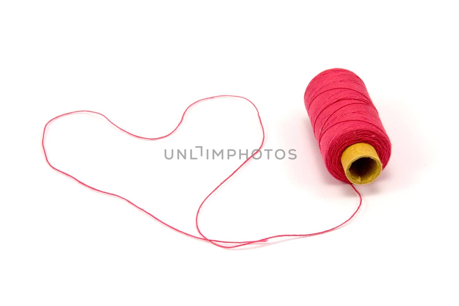 Heart shape made of red thread with spool