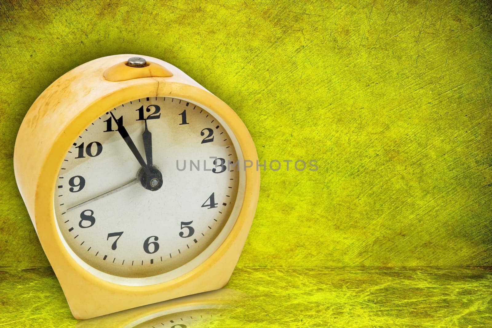 old scratched yellow clock on green background