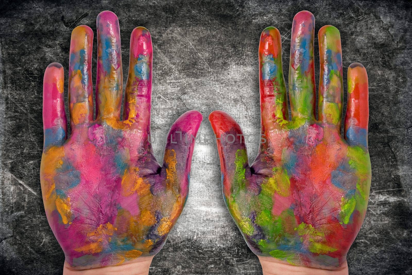 two painted human hands on dark background
