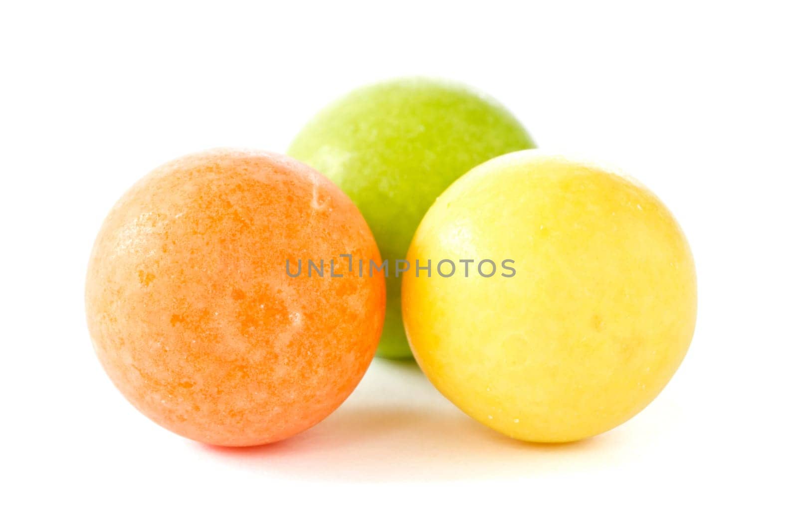 three color chewing gum balls on white background