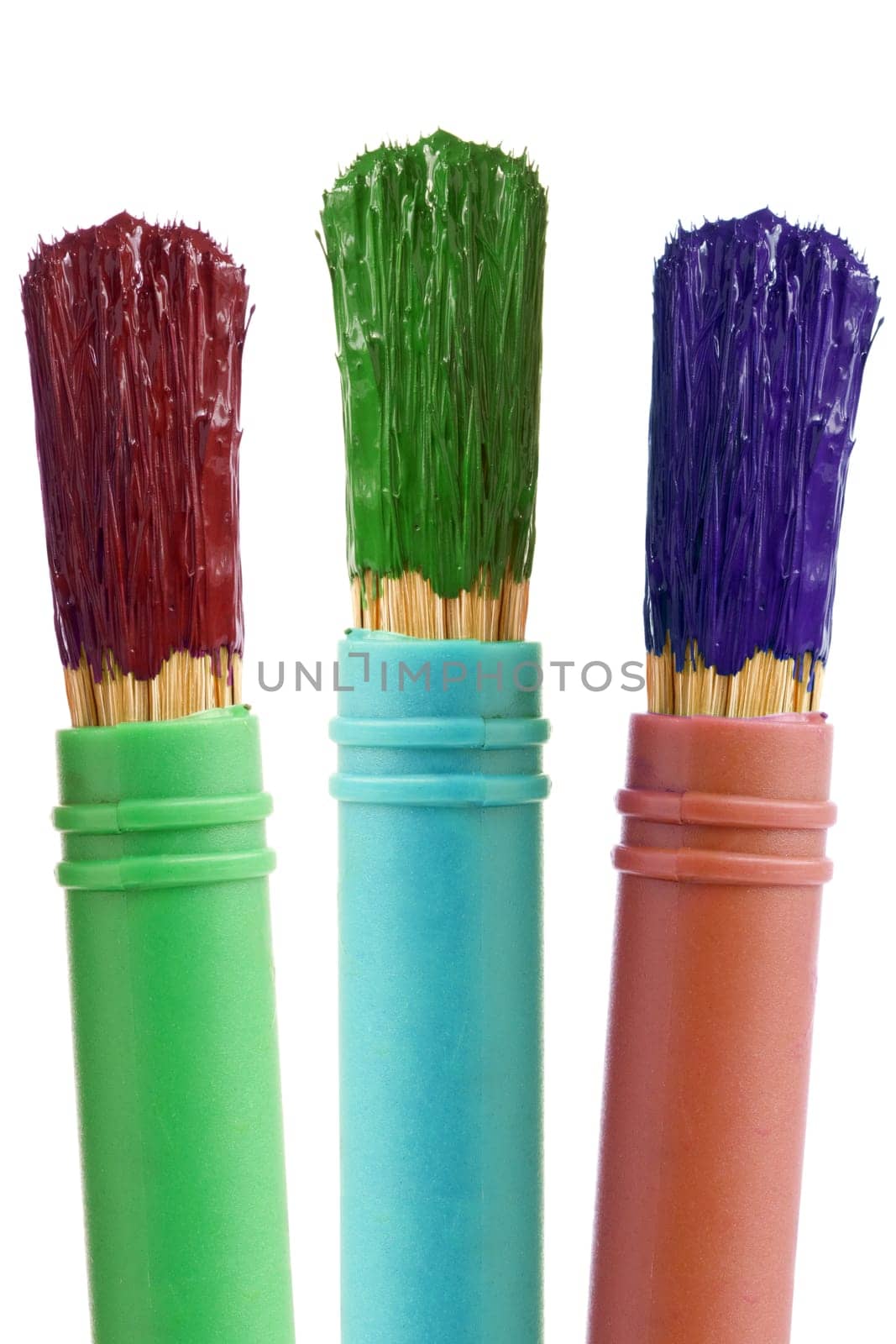 three paintbrushes with color paint. isolated on white background