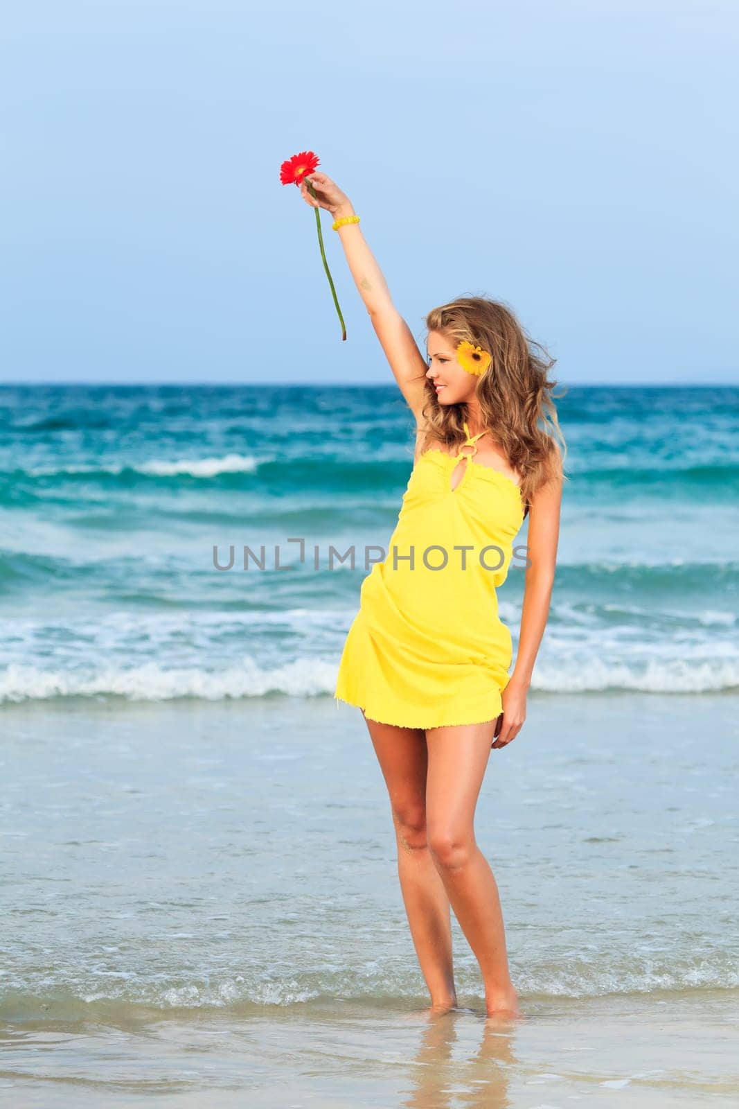 Beautiful woman in yellow dress on the beach