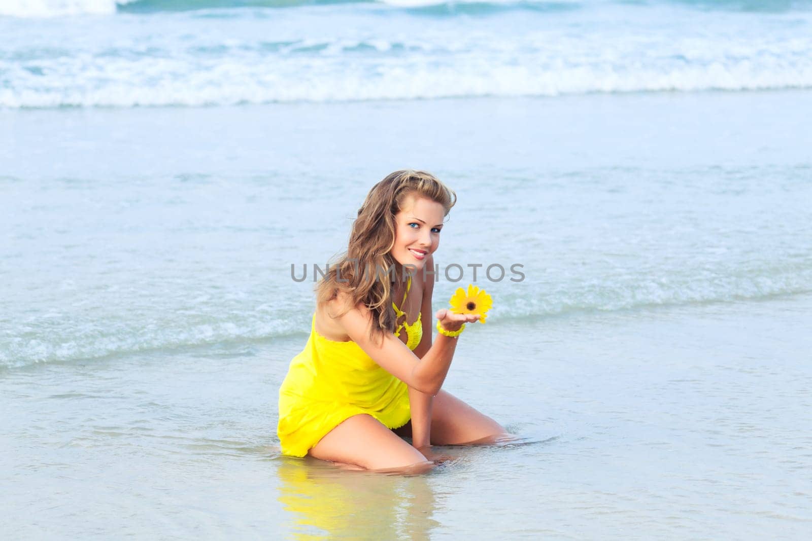 Beautiful woman in yellow dress on the beach