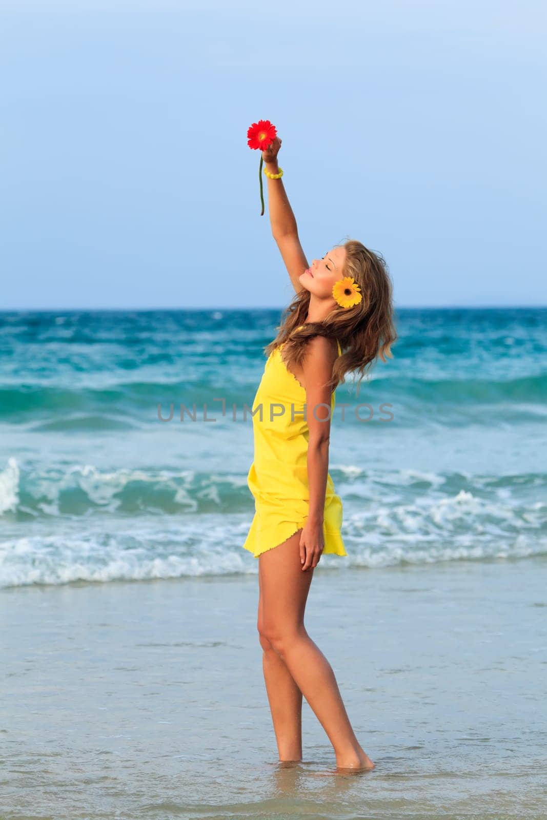 Beautiful woman in yellow dress on the beach