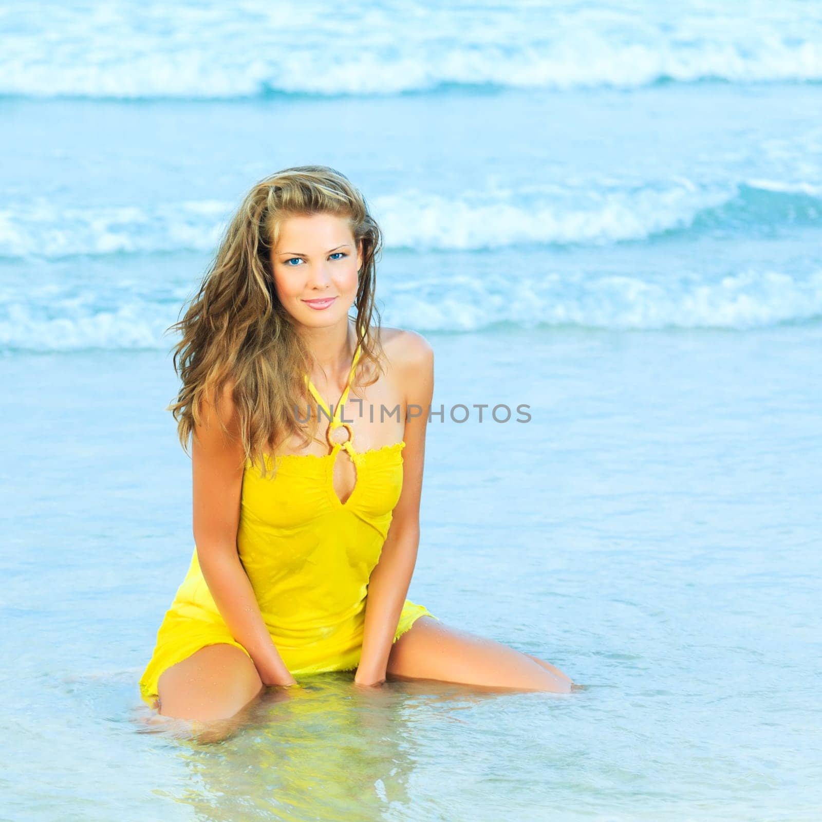 Beautiful woman in yellow dress on the beach