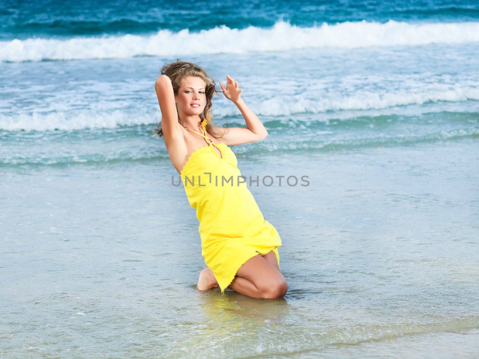 Beautiful woman in yellow dress on the beach