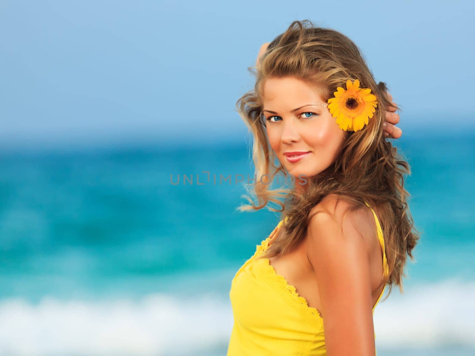 Beautiful woman in yellow dress on the beach