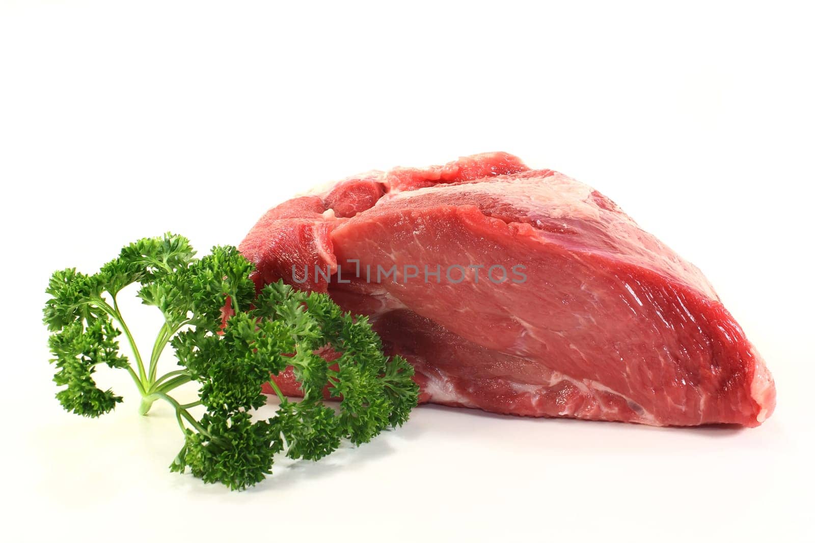a piece of raw roast pork with parsley