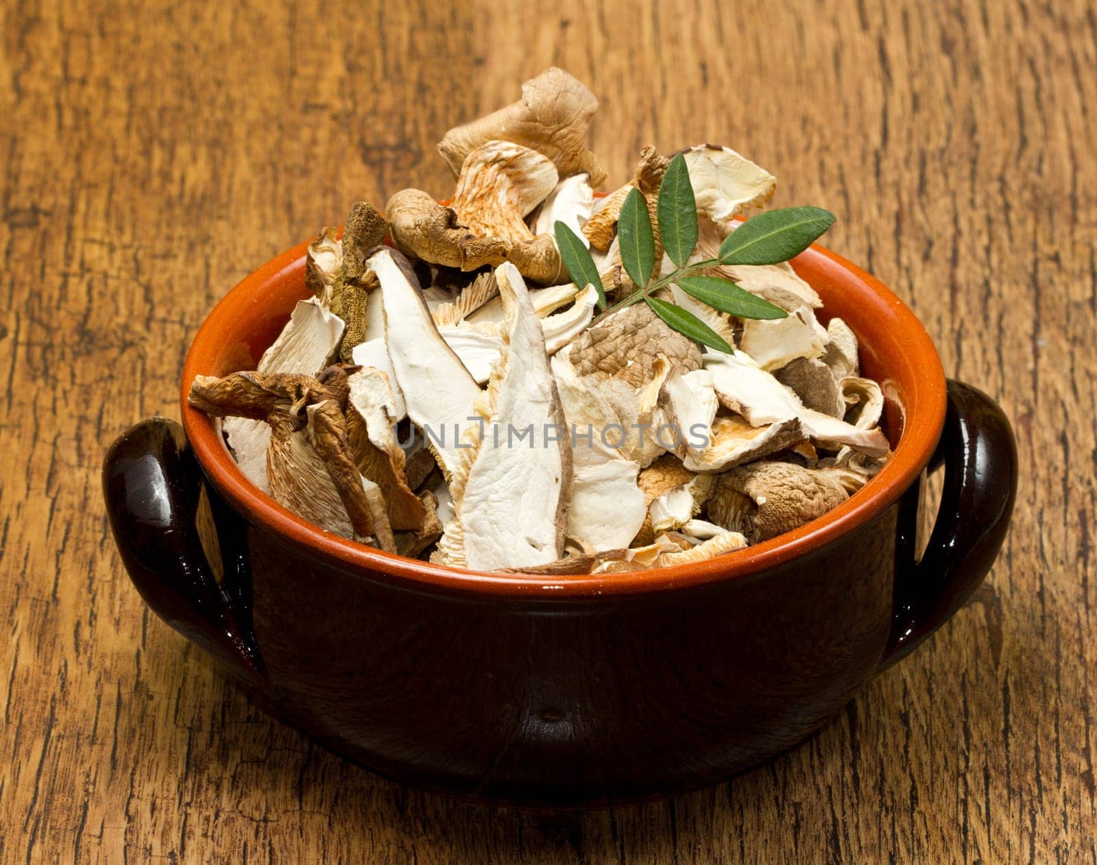 a bowl of dried mushrooms on wooden table