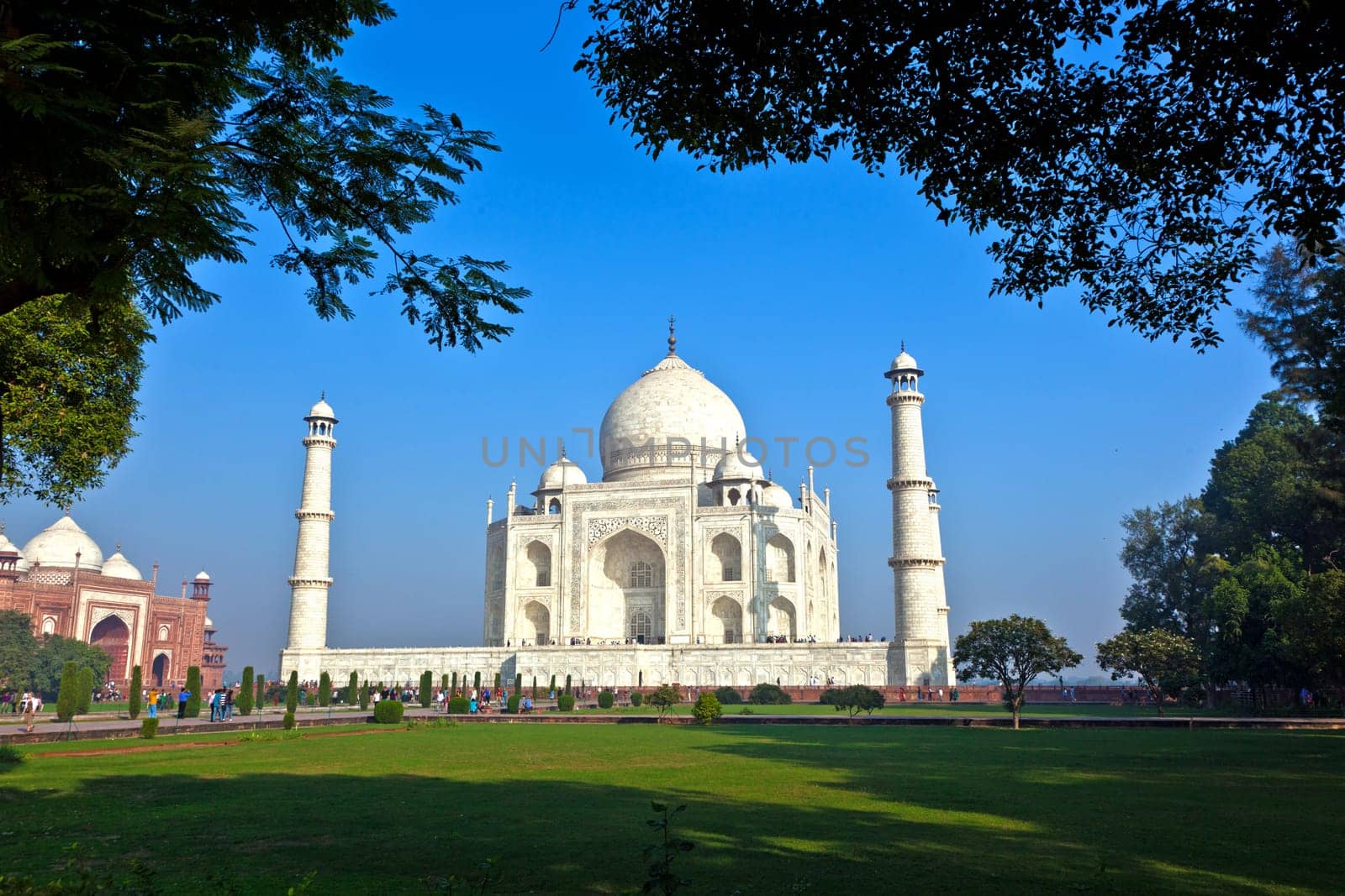 Taj Mahal in India in backlight seen from the arch of the mosque in early light