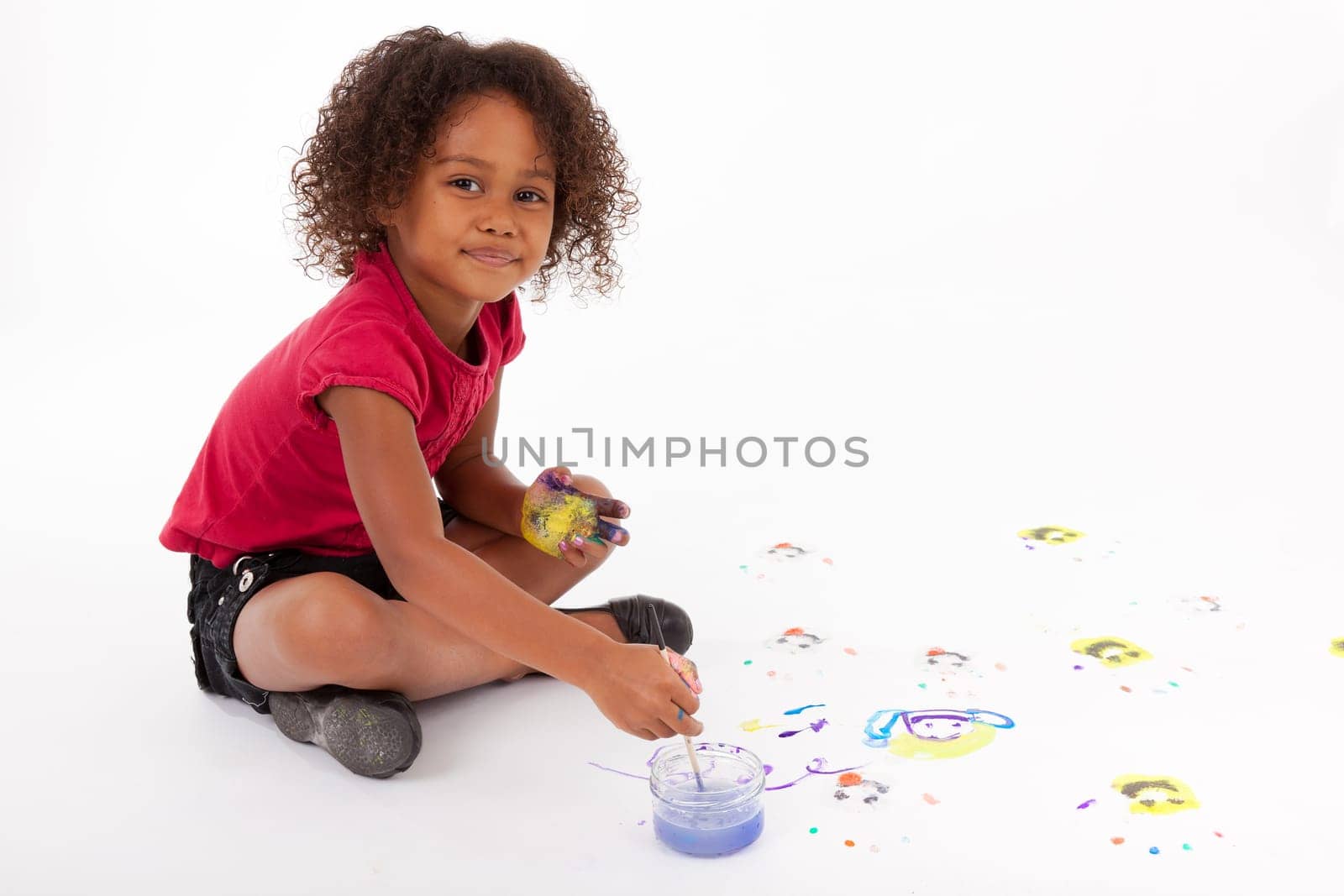 Cute Little African American girl painting on the floor
