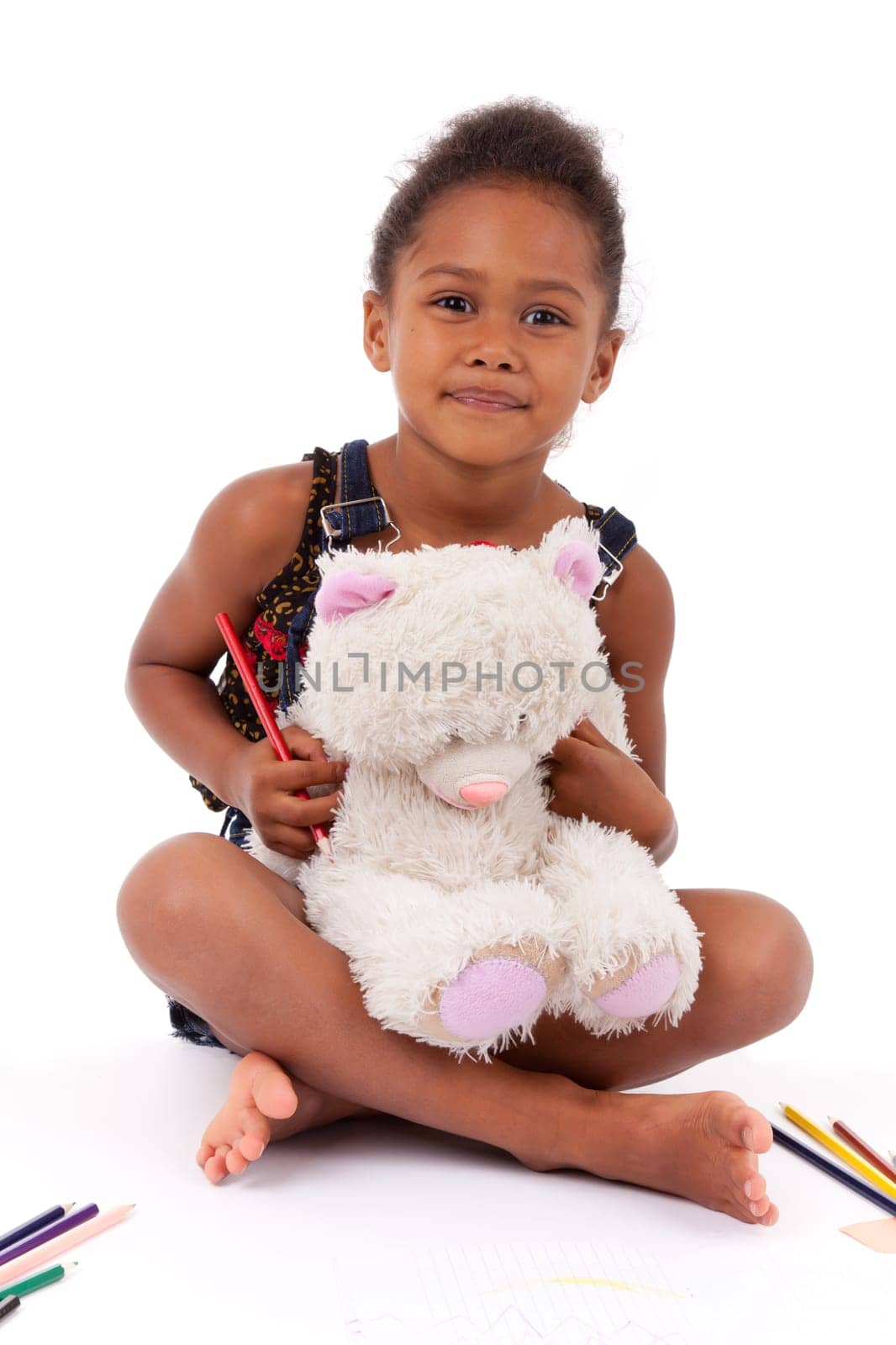 Little African Asian girl  drawing, sired  in  the floor