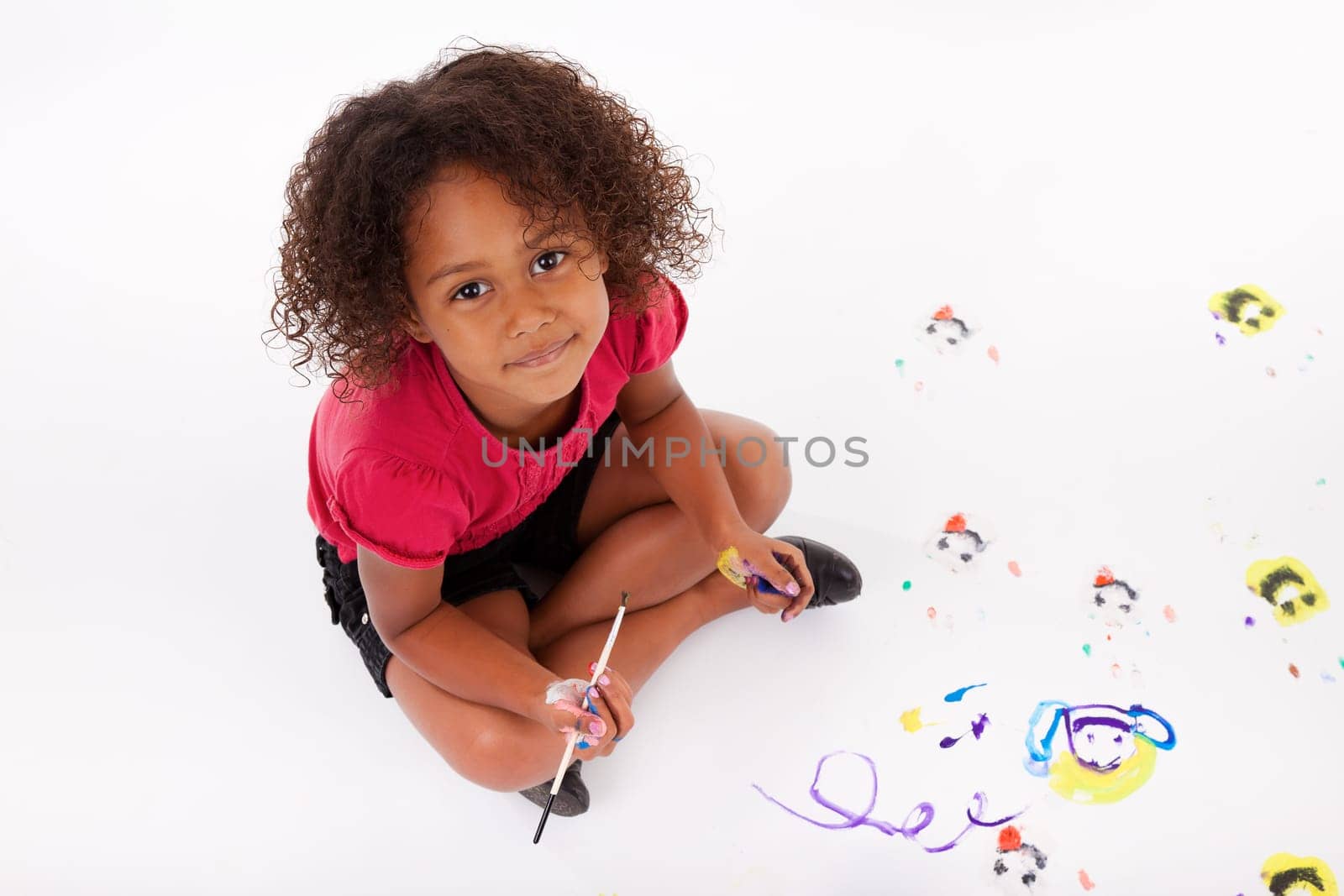 Cute Little African American girl painting on the floor