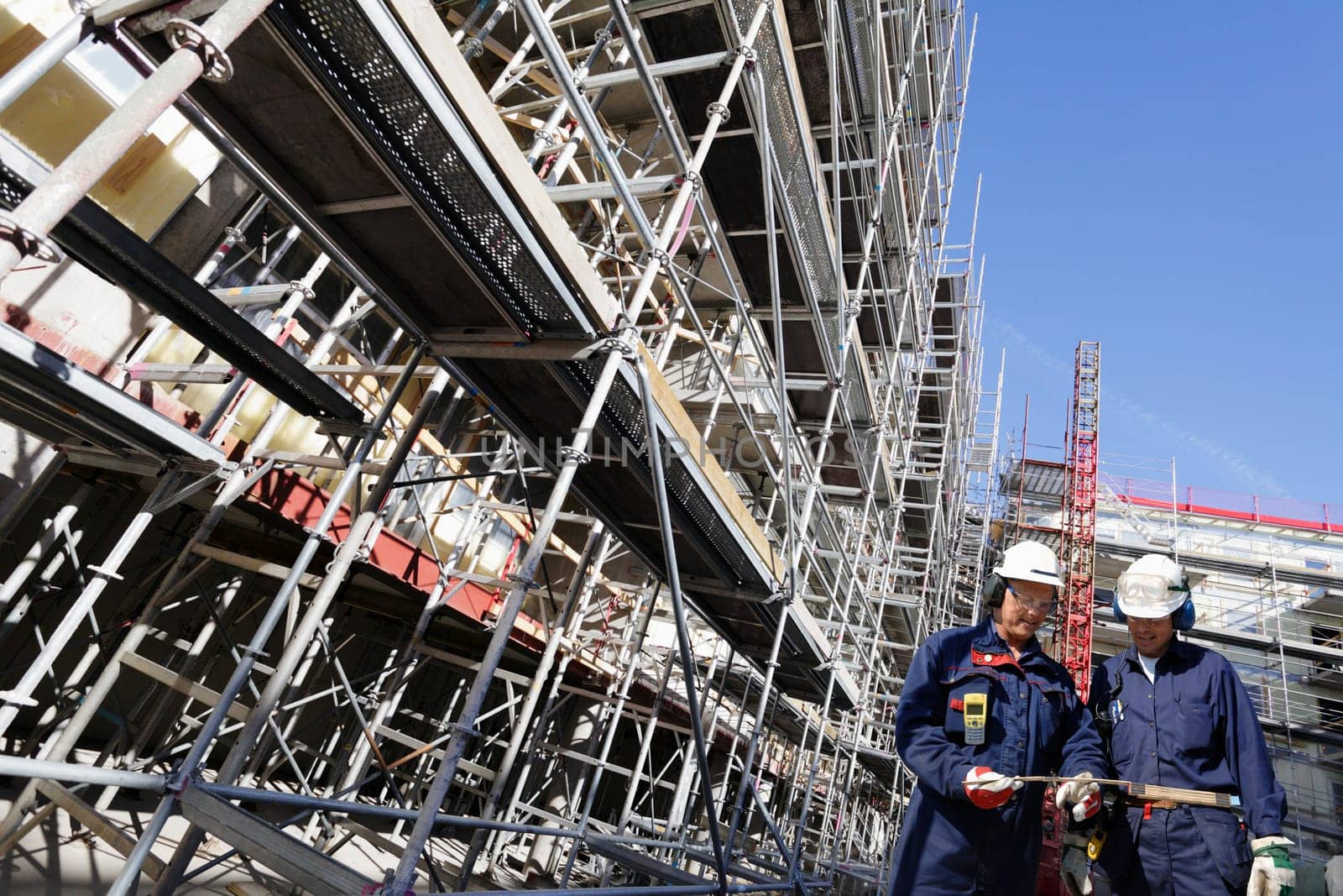 two building workers with large scaffolding constructions
