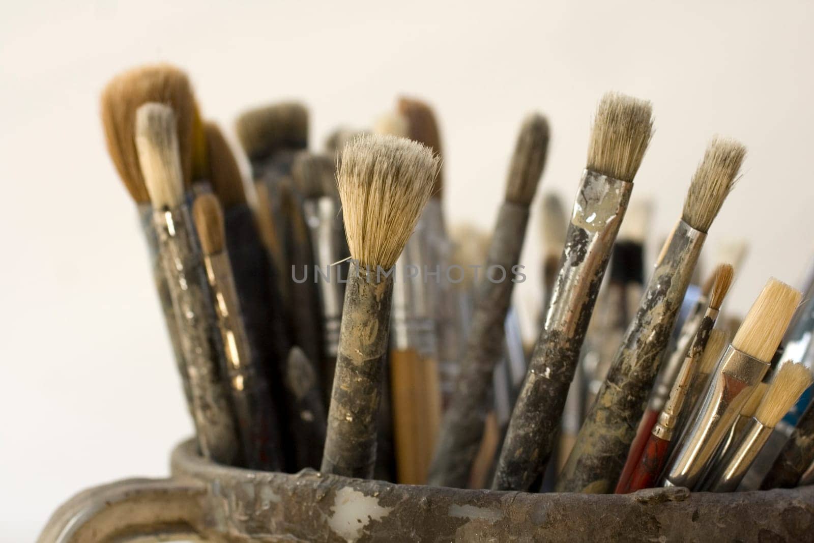 Paintbrushes inside a old jug
