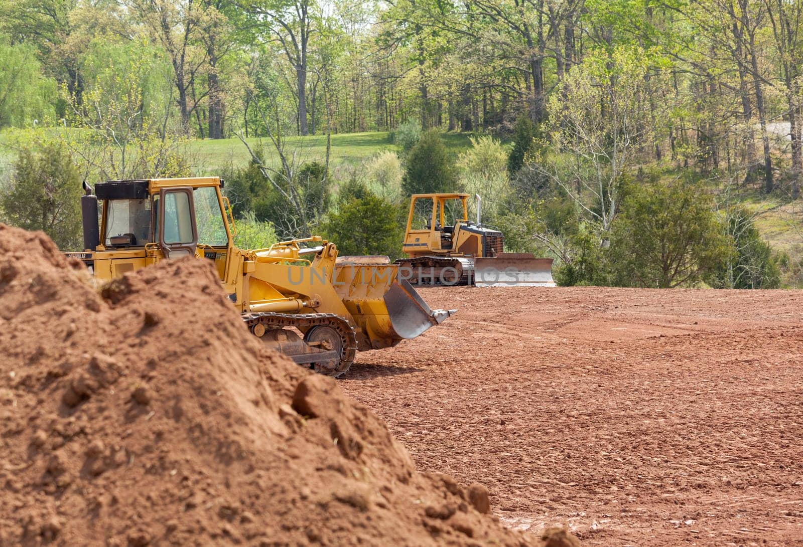 Land being levelled and cleared by yellow earth moving digger