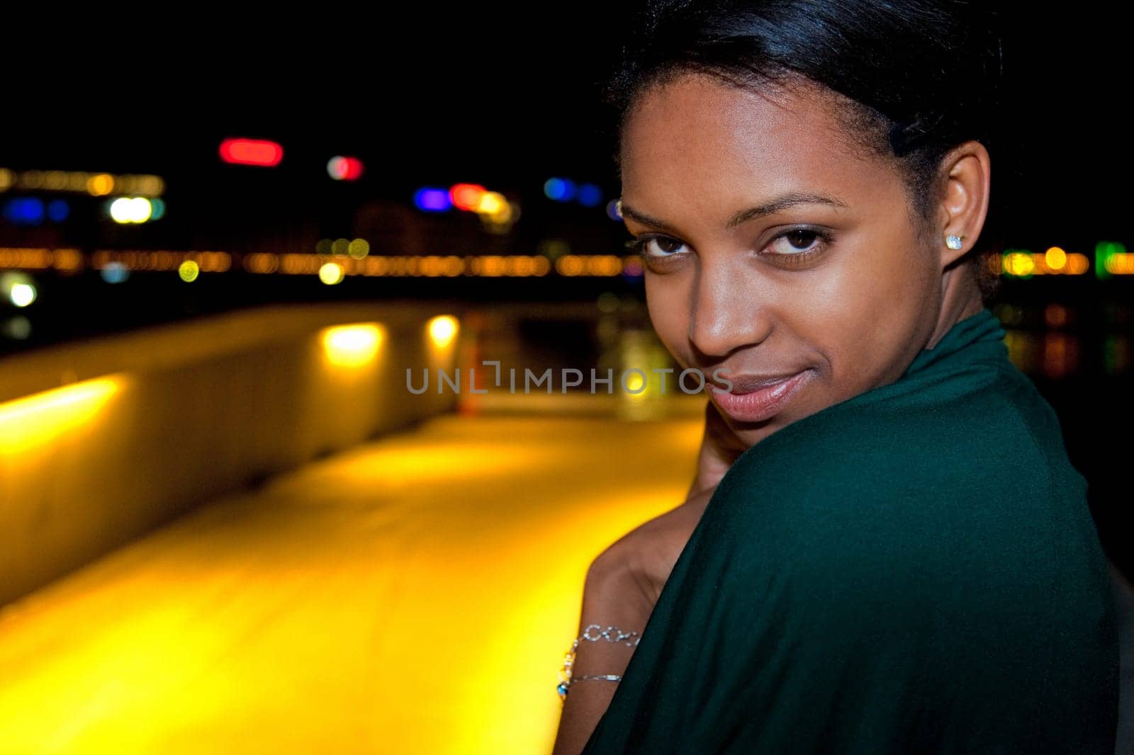 Portrait of young african american woman in city at night.