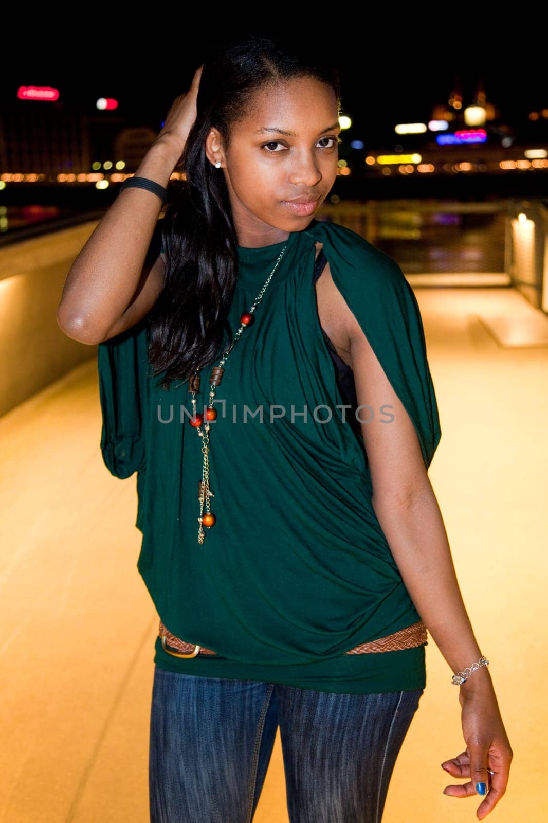 Portrait of young african american woman in city at night.