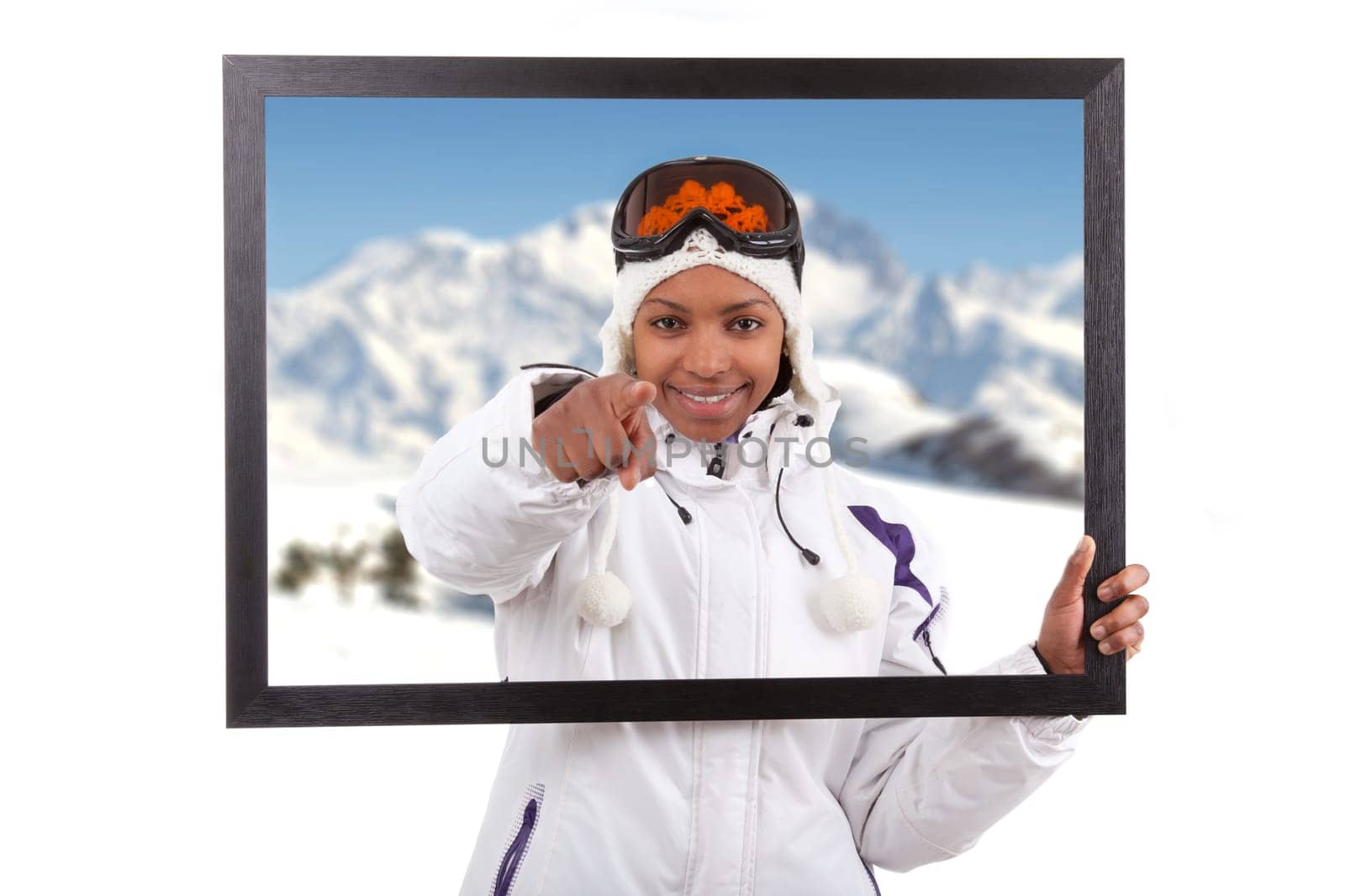 Young smiley woman in ski gears  holding a picture frame, isolated on white background