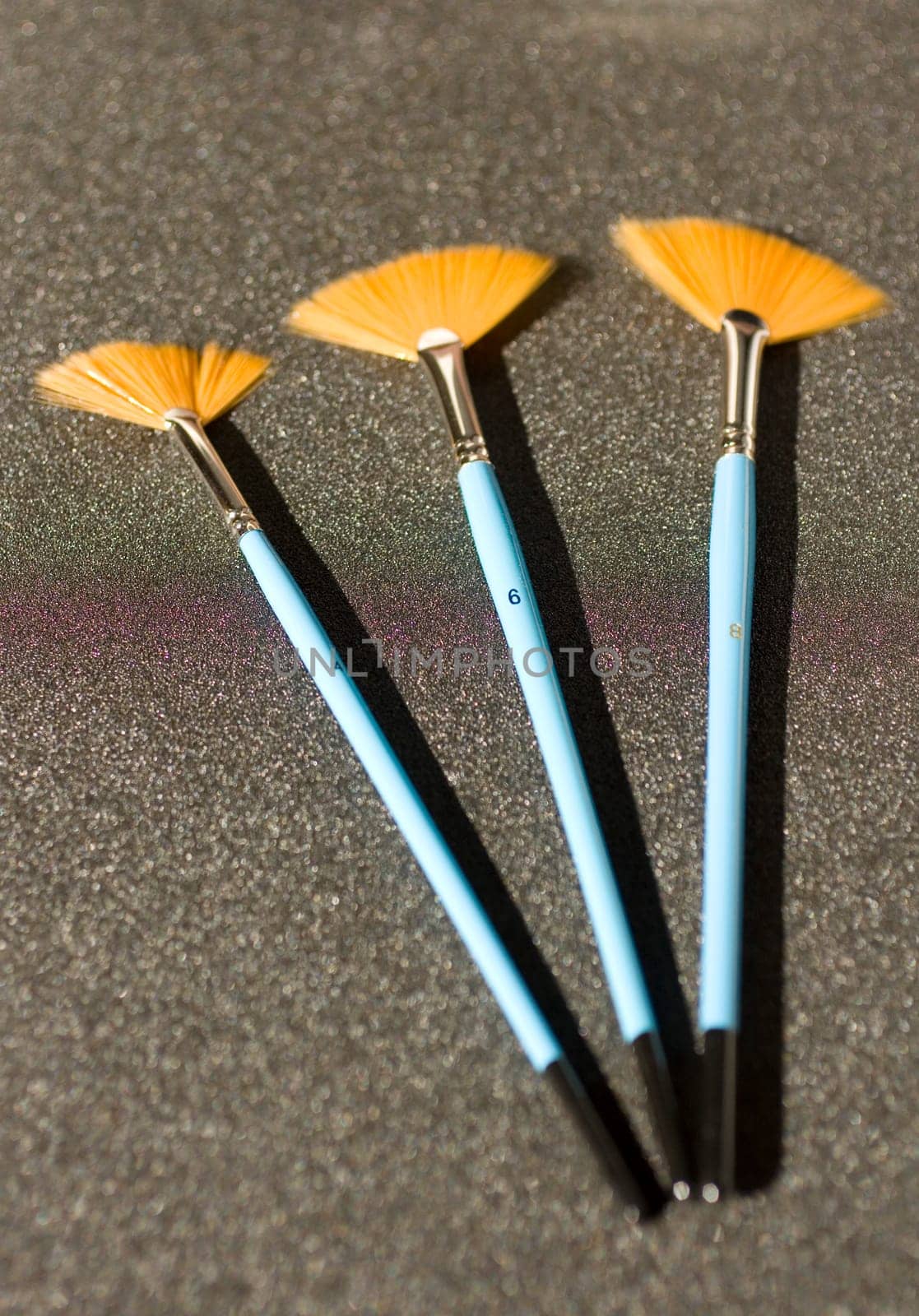 Fan shaped paintbrushees on anthracite background