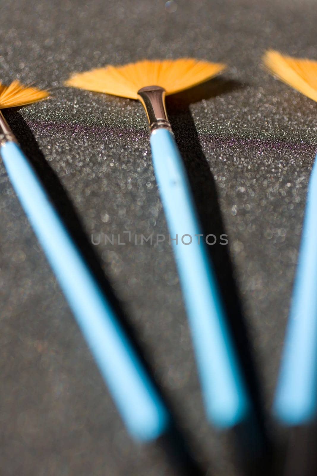 Fan shaped paintbrushees on anthracite background