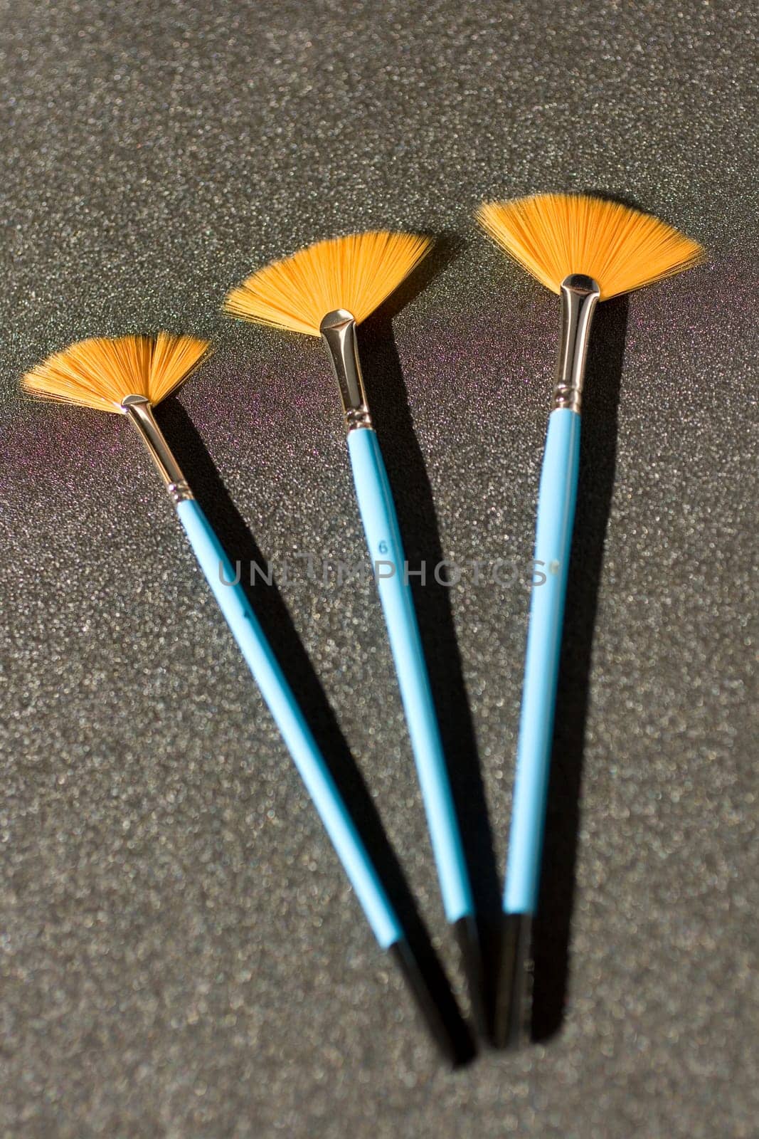 Fan shaped paintbrushees on anthracite background