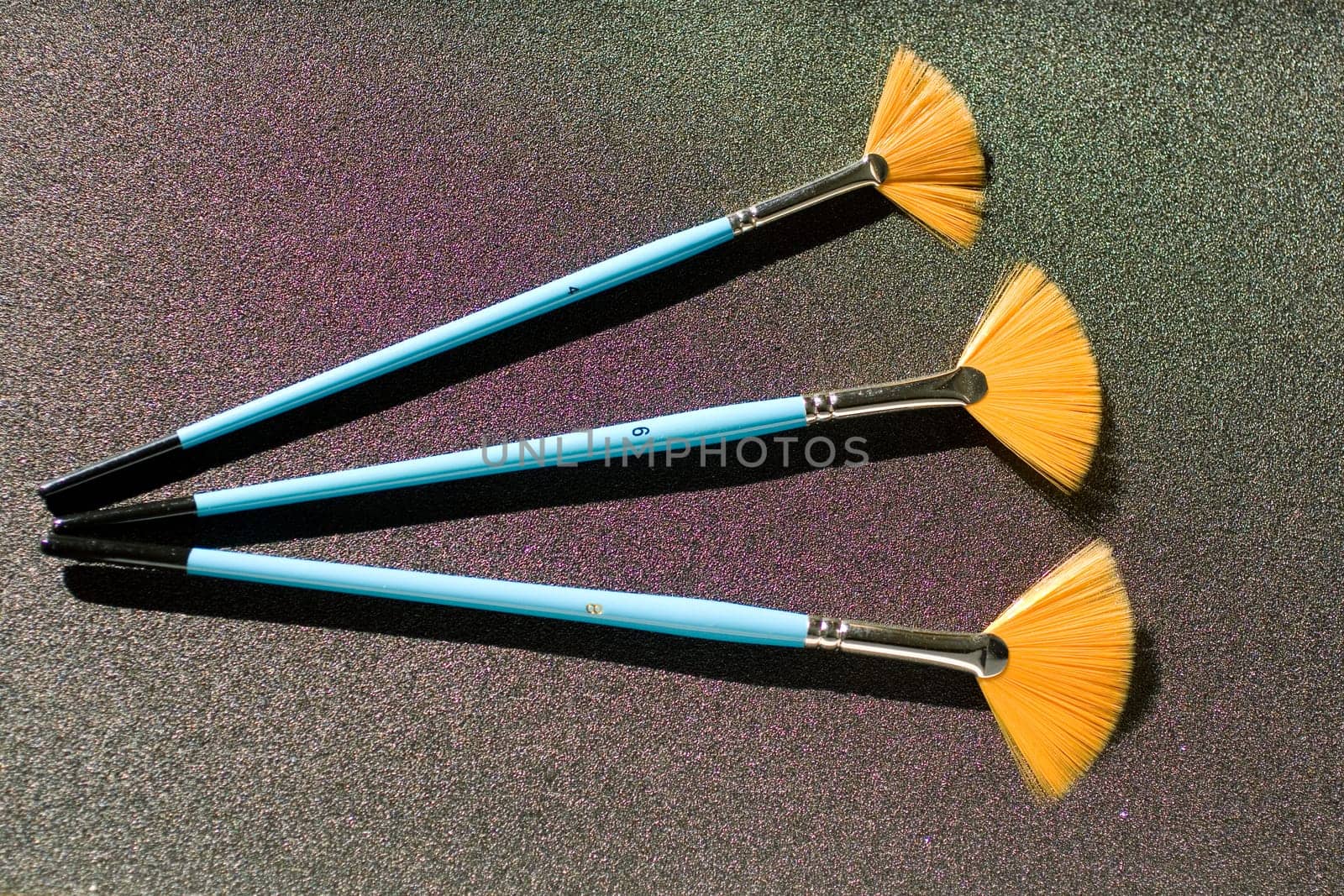 Fan shaped paintbrushees on anthracite background
