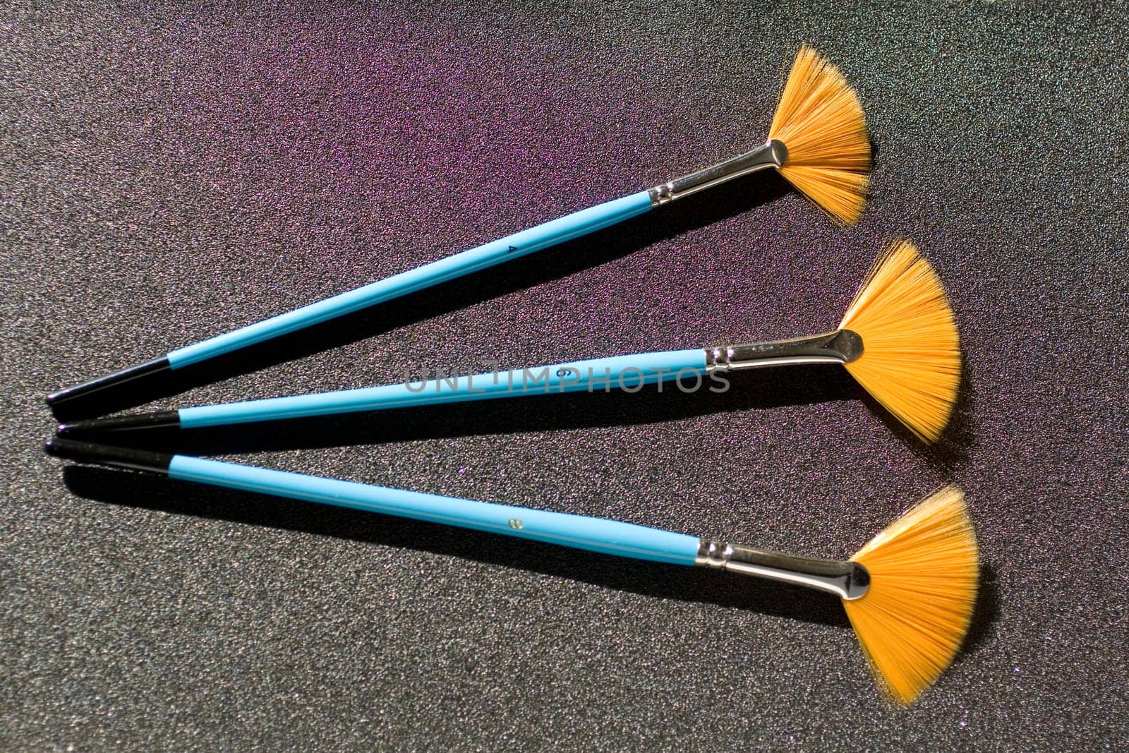 Fan shaped paintbrushees on anthracite background