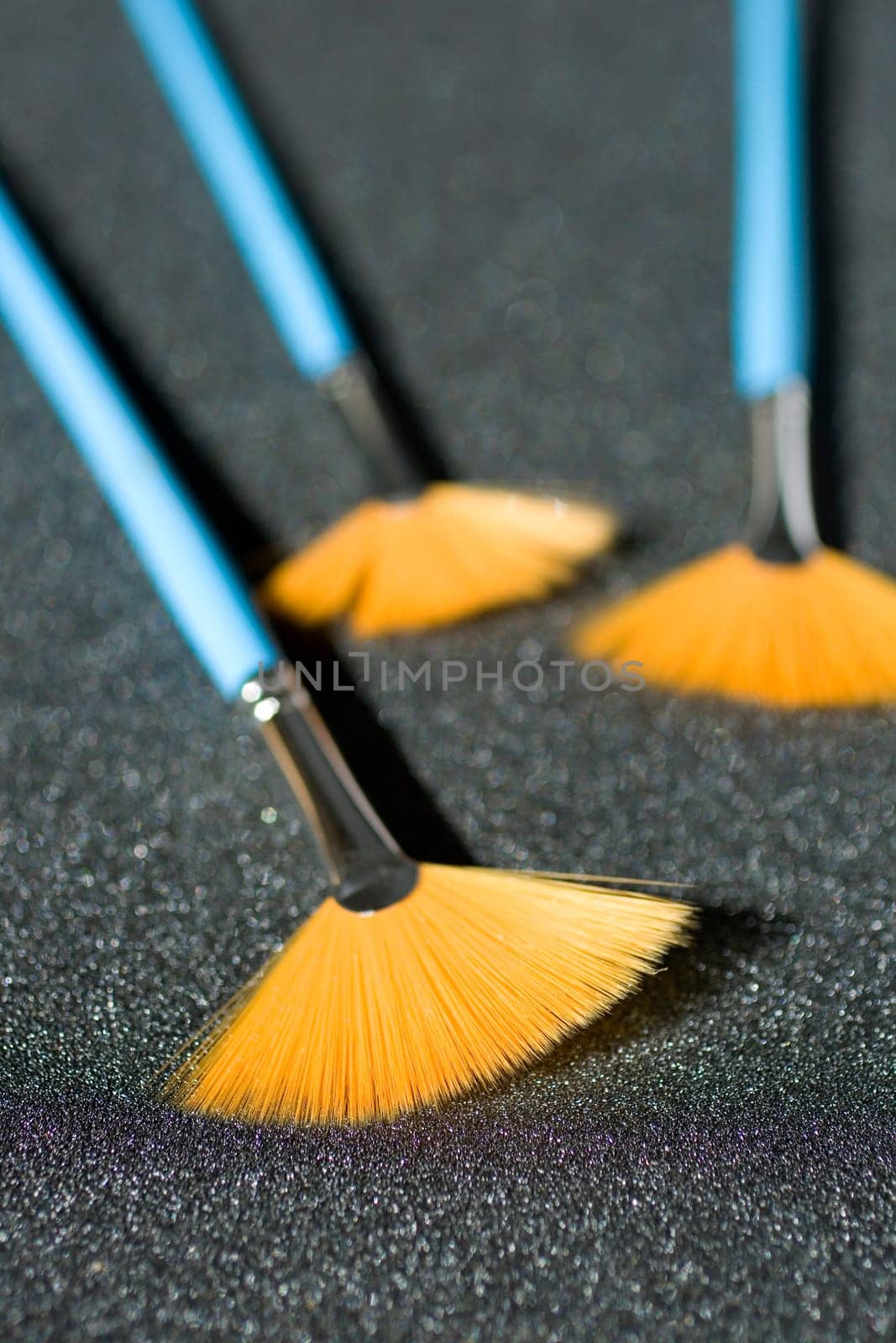 Fan shaped paintbrushees on anthracite background