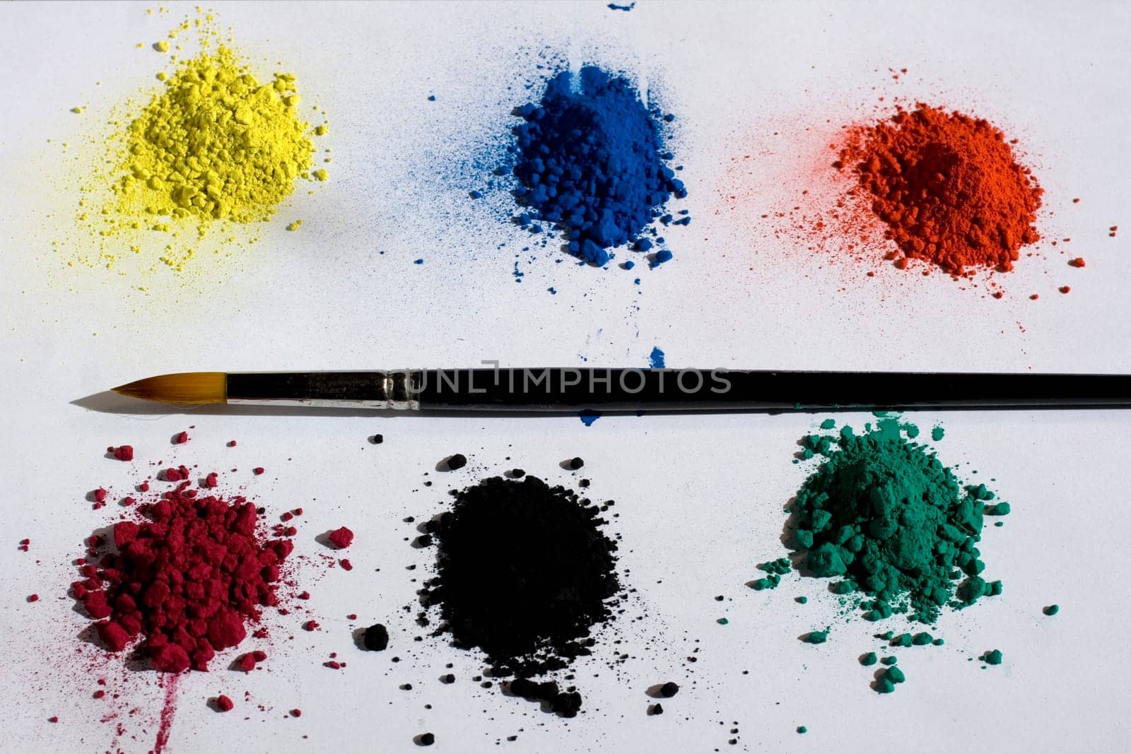 Various pigments colors and brush on a white backround